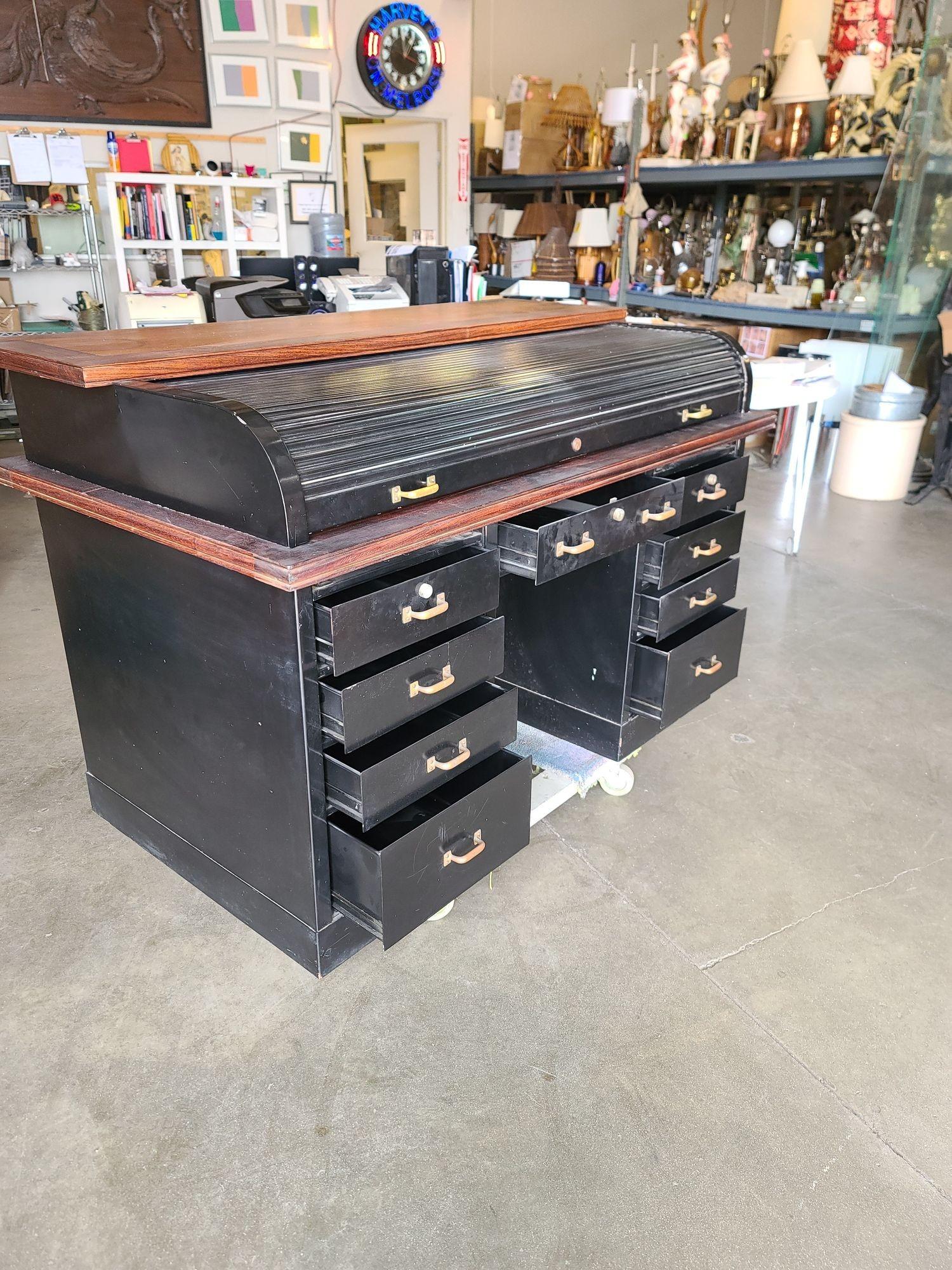 Heavy Industrial metal desk with functional roll top. Opens to an original green rubber flat desk top with multiple compartments. Brass hardware highlights the masculine striped metal finish. A hard to find, one of a kind!
