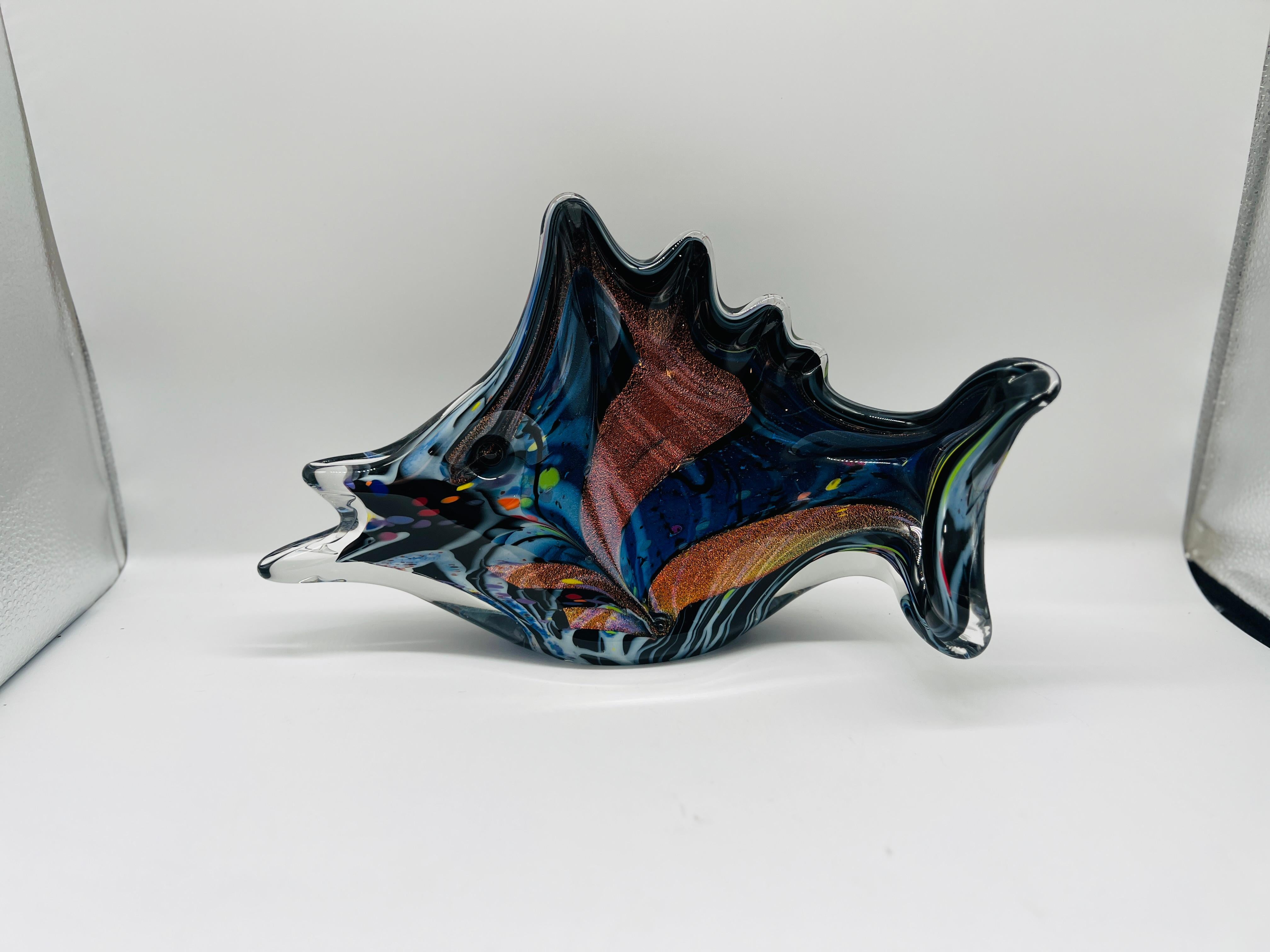 This stunning large art glass sculpture by renowned artist Rollin Karg, created in 2009, is an exceptional example of contemporary glass artistry. Shaped into a dynamic fish form, the sculpture features dichroic glass, which displays mesmerizing