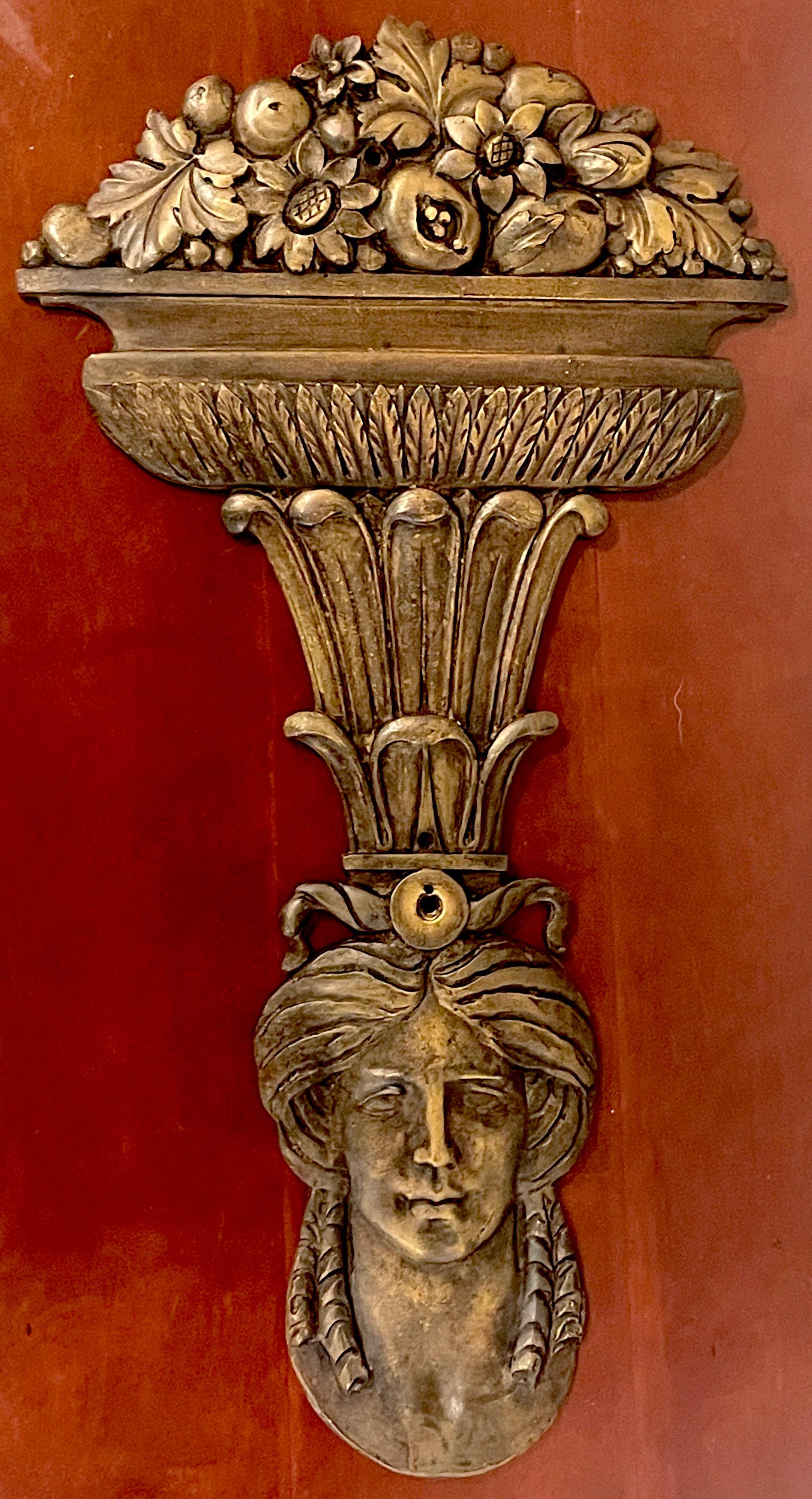 Large Roman style bronze figural architectural element, depicting a goddess holding on her head an acanthus column with a bronze urn cascading with flowers, fruits and leaves. 
Drilled with three mounting holes in the middle and one at the top,