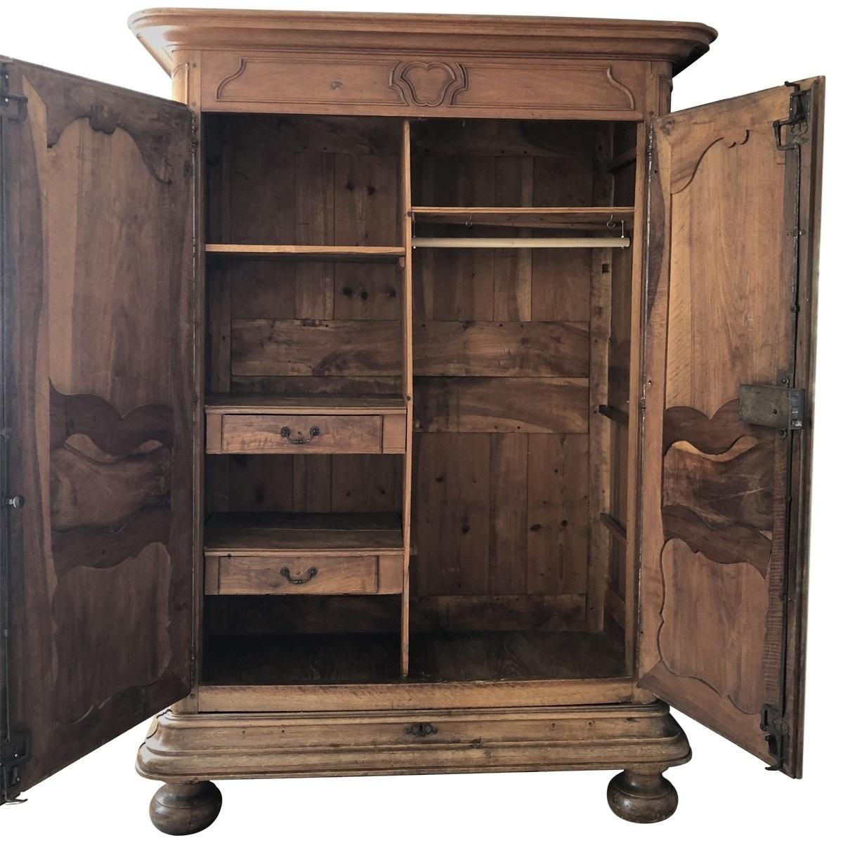Very large beautiful 18th century French Louis XV hand carved solid cherrywood wardrobe having raised and recessed door panels with flowing curves and beaded edges. The doors are mounted on external steel hinges with filigree steel key guards and