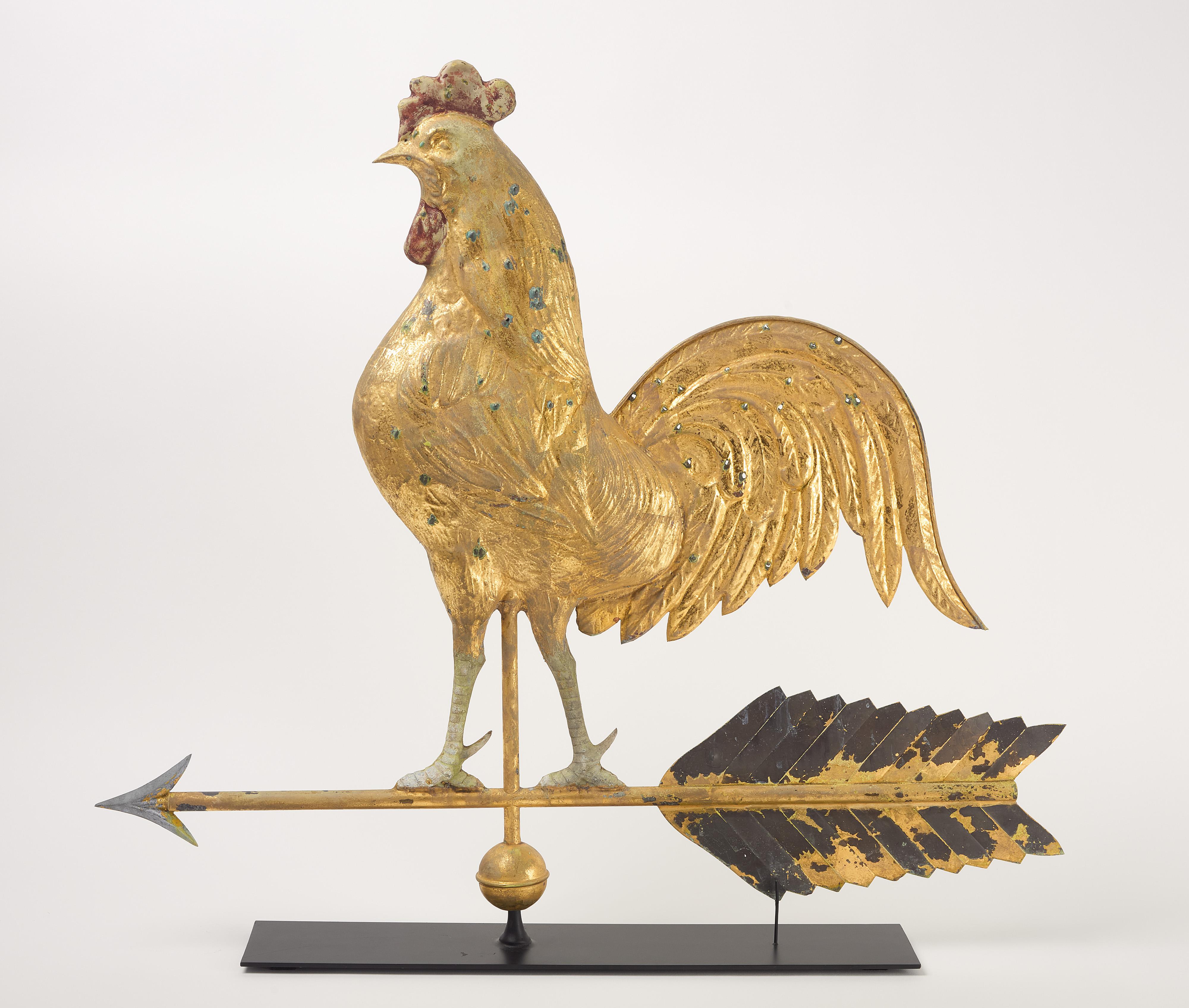 Veleta de gallo grande. Cuerpo de cobre moldeado con superficie dorada. Patas de zinc fundido. Muy probablemente por J.W. Fiske, Nueva York. Finales del siglo XIX. Soporte de exposición incluido.