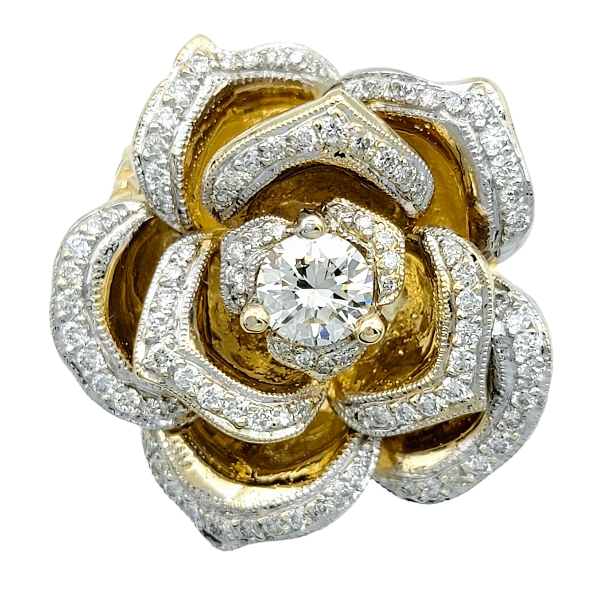 Ring Size: 7

This large cocktail ring is a stunning statement piece designed in the shape of a rose, crafted in 14 karat white and yellow gold. At the center of the flower sits a prominent diamond, surrounded by pave diamonds that beautifully adorn