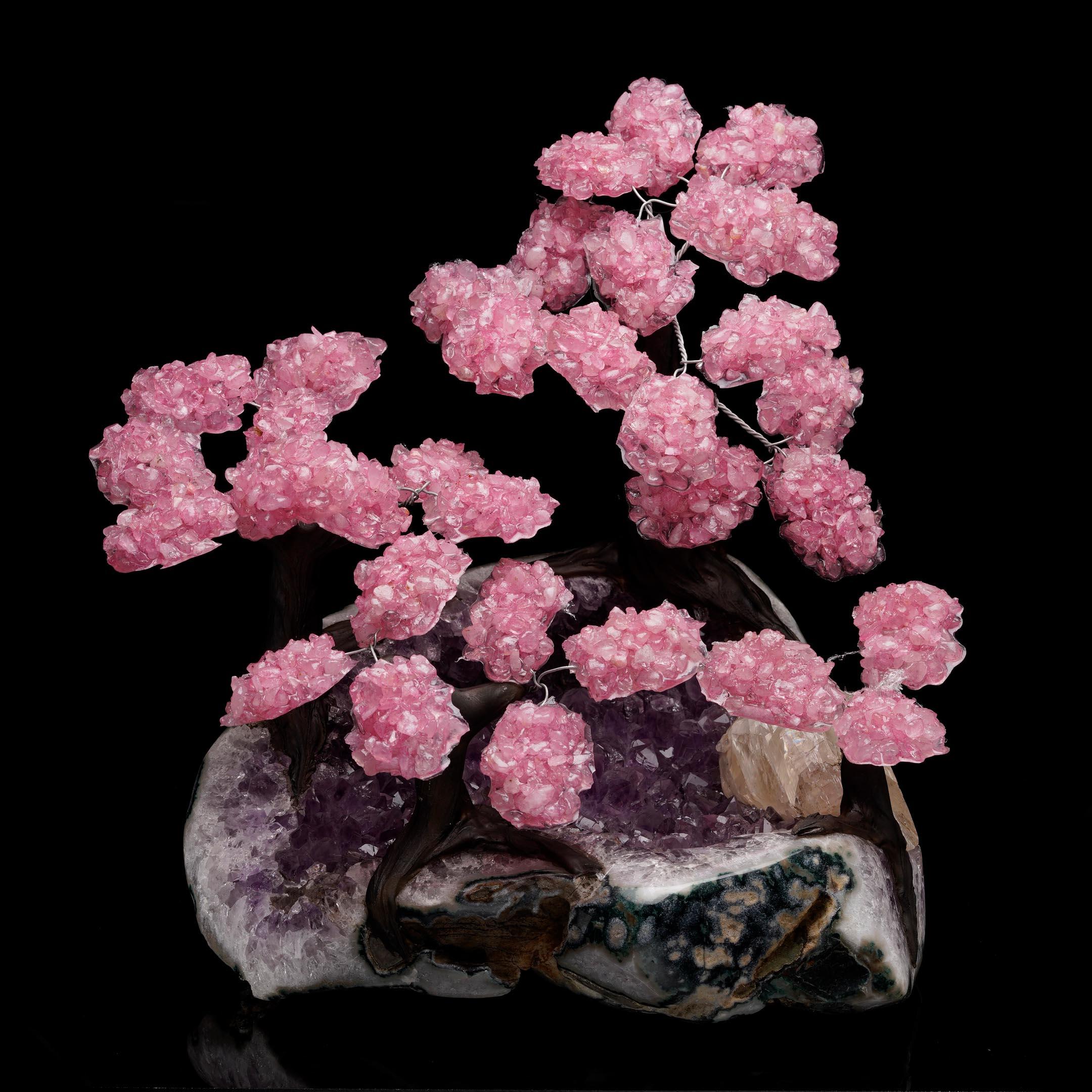 Estos árboles de gemas de Cuarzo Rosa son una auténtica obra de arte y una muestra de armonía mineralógica. Meticulosamente elaboradas a mano con cristal natural, las vibrantes hojas de Cuarzo Rosa de los árboles se han dispuesto expertamente en
