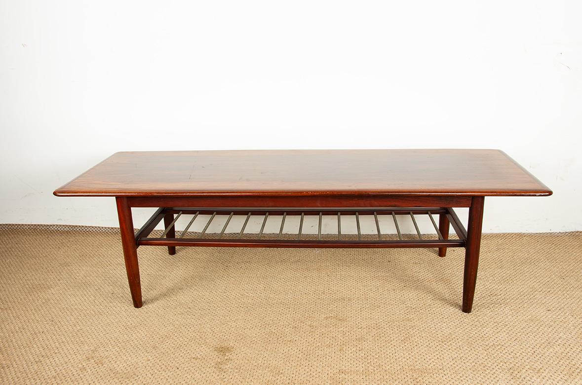 Beautiful Scandinavian coffee table. 
Long rosewood coffee table resting on four legs joined by a spacer shelf made of tubular metal rods, circa 1960. Superb craftsmanship, a very elegant piece of furniture.

Designer: In the style of Kai