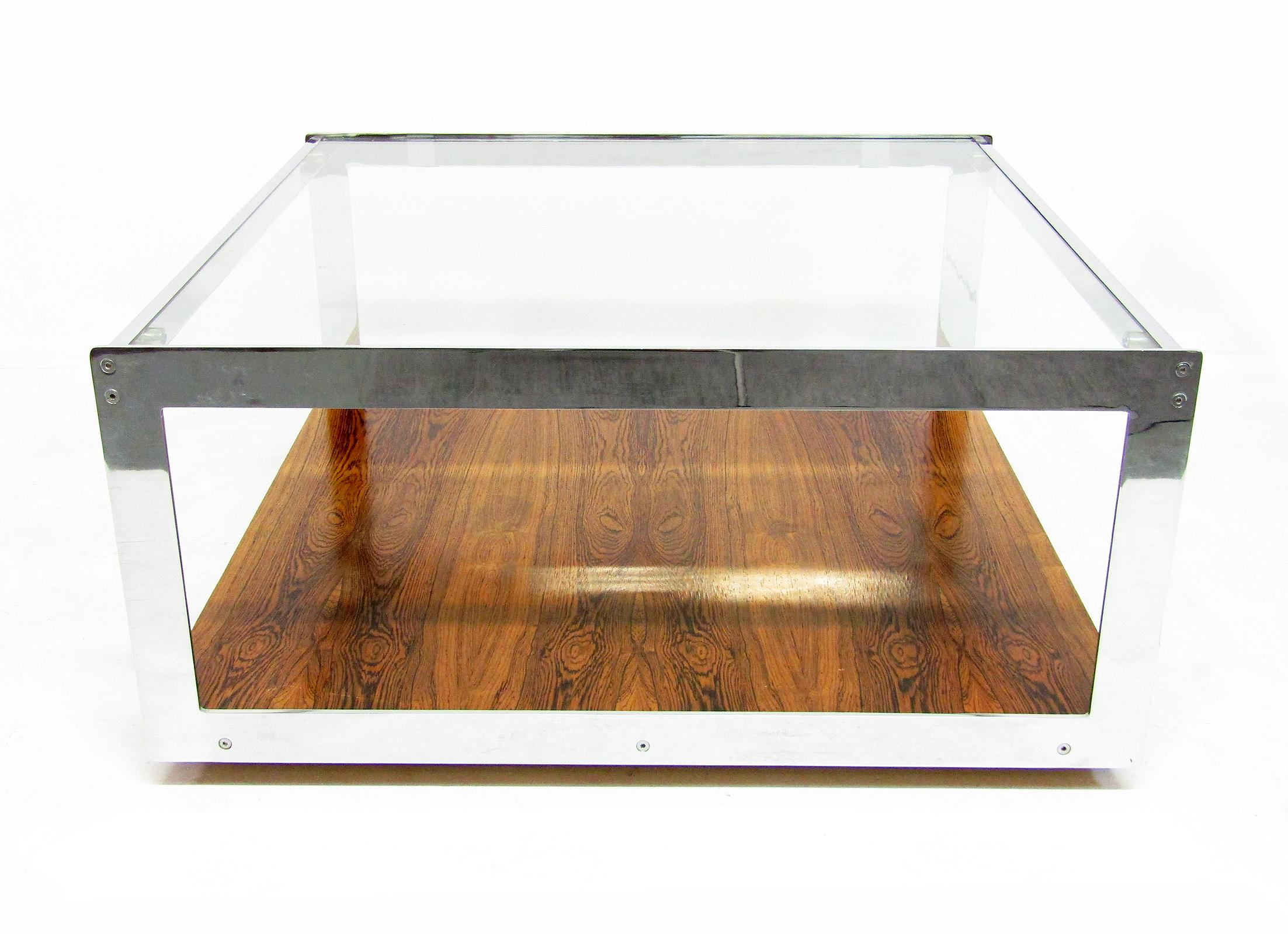 A large 1970s centre coffee table in rosewood veneer and chrome frame by Richard Young for Merrow Associates.

This wonderful slab of minimalism is the larger size of center tables made by Merrow. It slides easily on smooth casters.

The rosewood
