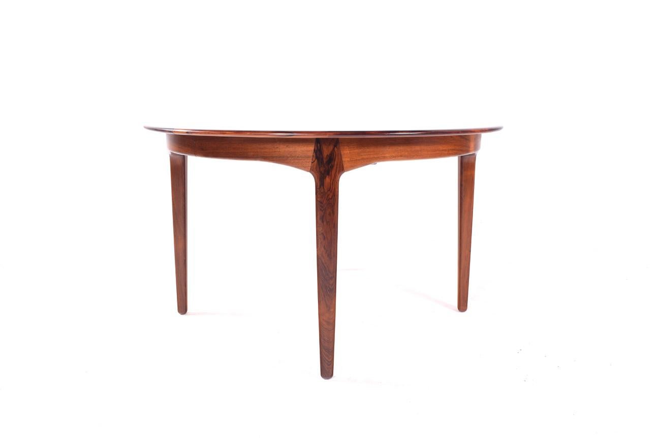 Elegant Danish dining table, model #62 in rosewood. Designed in 1958 by Henning Kjærnulf for Sorø Stolefabrik. Large-scale table featuring a drop-down tripod support base and four leaves. Extremely well designed and manufactured table. Each leaf has