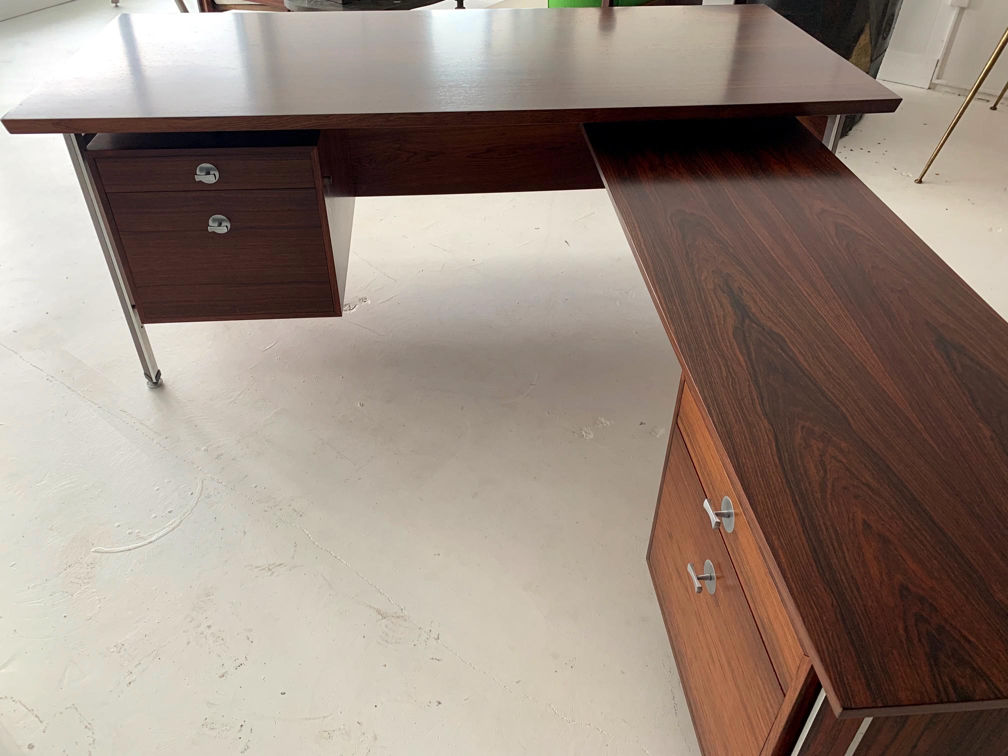 An impressive L shape executive desk designed by Finn Juhl as Diplomat series for Frances and Son, circa 1960s. Constructed with matching rosewood veneer with dramatic grains and aluminum frame, the desk features an adjustable L return on the right