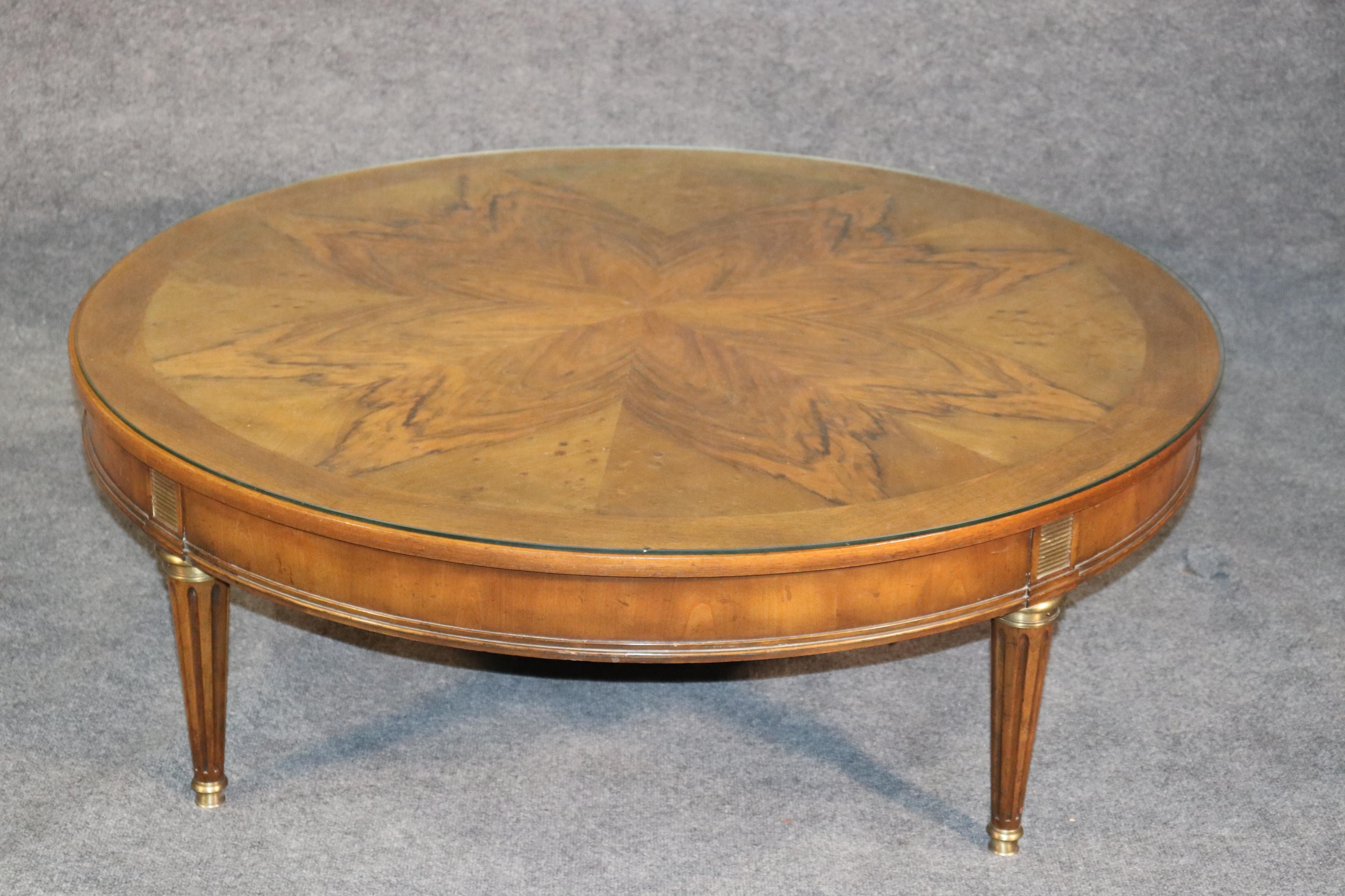 This is a beautiful light walnut 48 x 48 x 16 inch tall Baker coffee table. The table is in good condition and is a lighter tone walnut. The brass details add just a touch of bling to an otherwise understated form. Dates to the 1960s era.