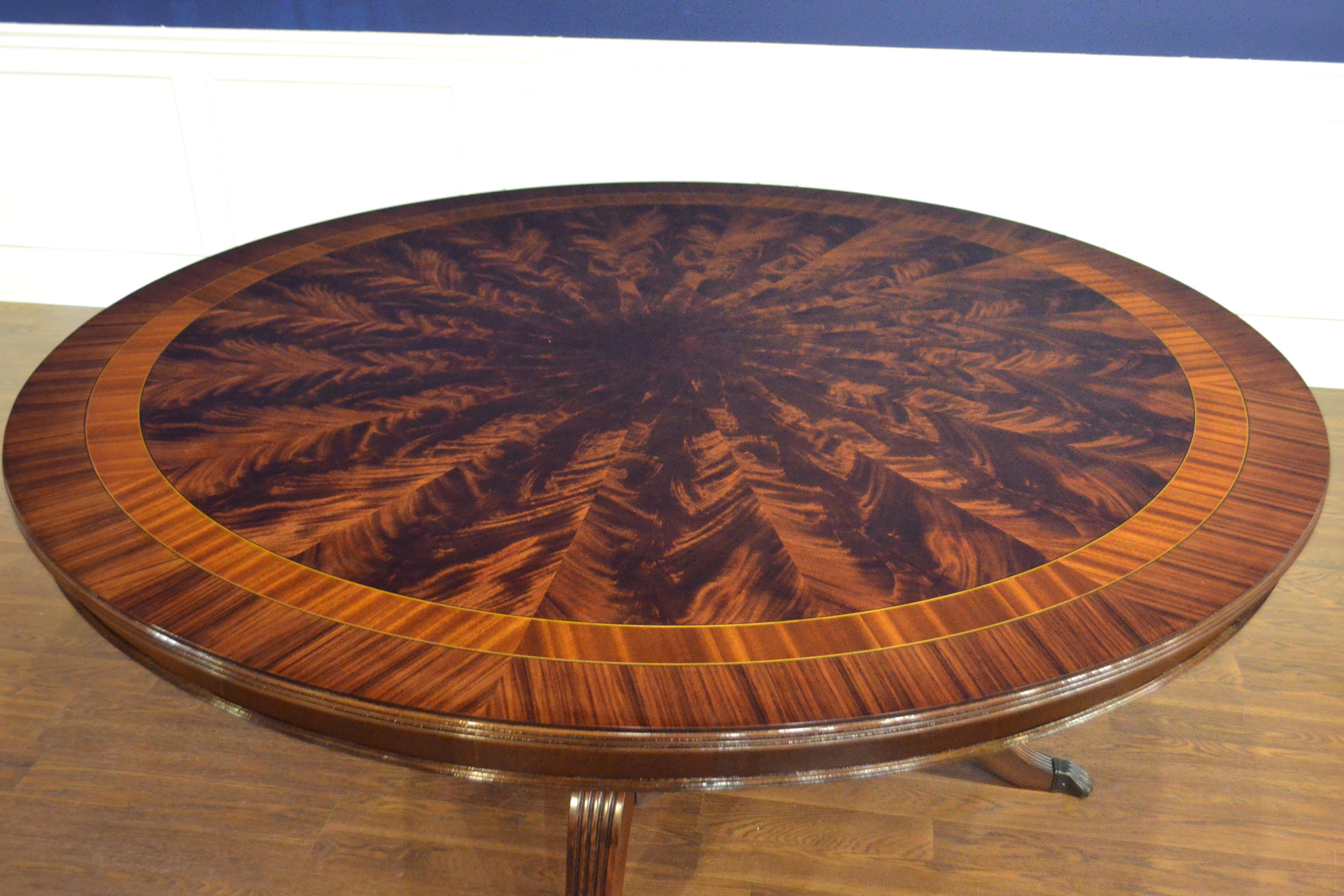 This is made-to-order large round traditional mahogany dining table made in the Leighton Hall shop. It features a radial cut field of west African swirly crotch mahogany and two borders of straight grain mahogany and Pau Ferro. It has a hand rubbed