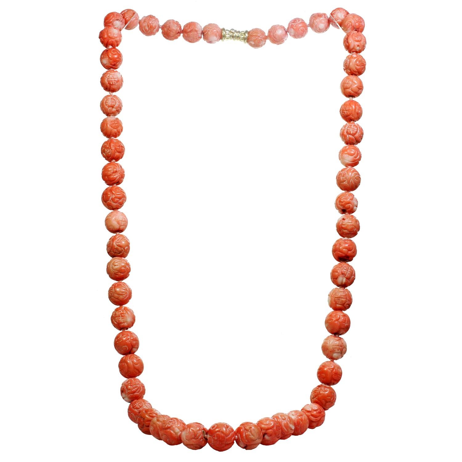 This long gorgeous vintage necklace features 55 carved rose-orange coral beads measuring between 14.0mm -17.0mm in diameter and compeleted with 14k yellow gold clasp. Made in United States circa 1970s. Measurements: 36