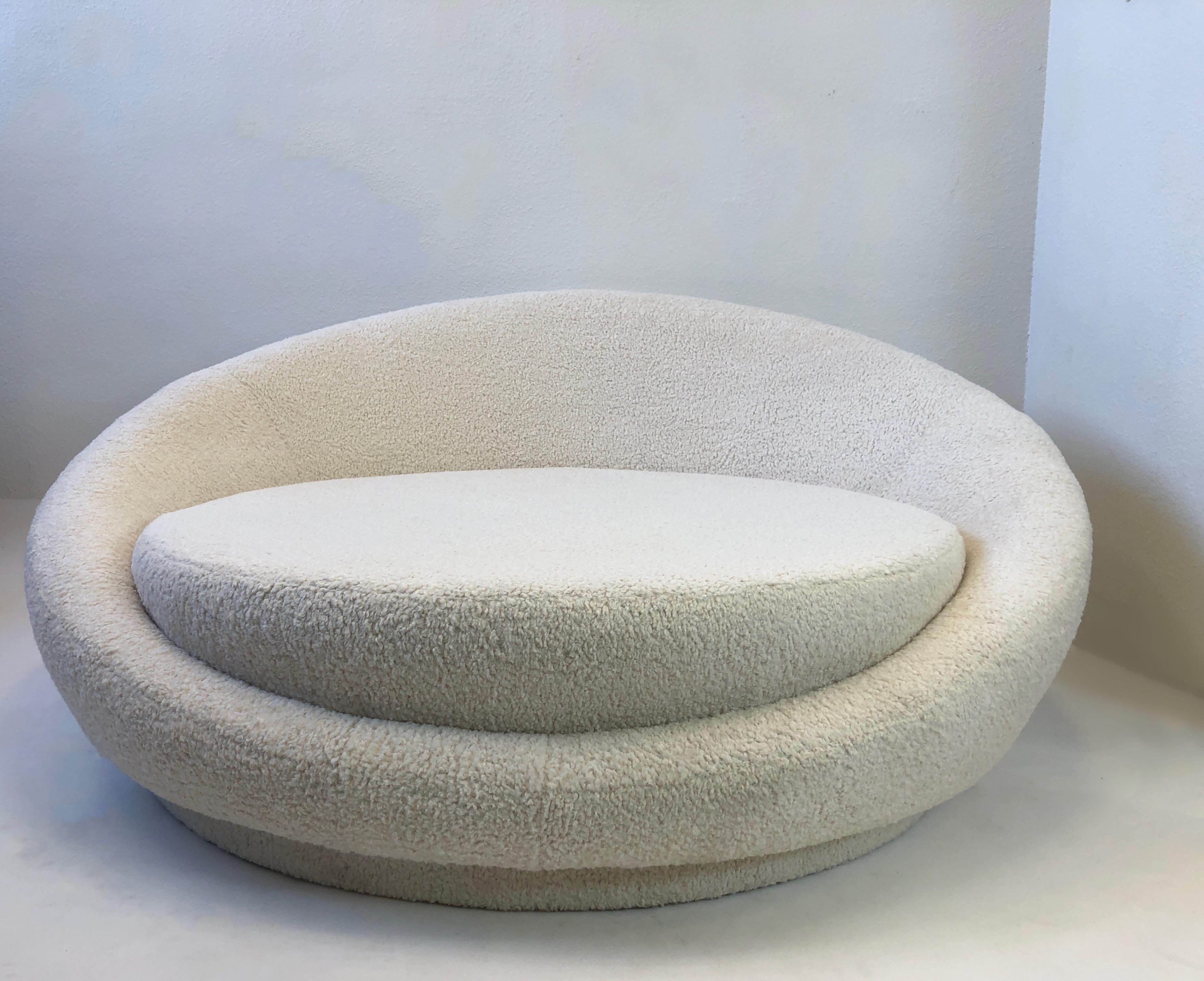 Glamour 1970’s large round ‘Satellite’ chaise on casters. 
Newly recovered in a soft natural boucle fabric. 
Measurements: 62” wide, 60” deep, 28” high, 19” seat with cushion, 15” seat without.