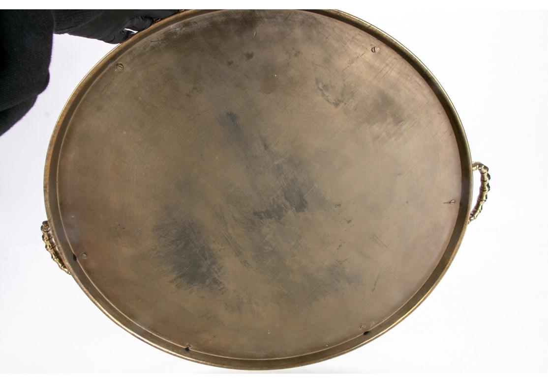 Large round brass serving tray with faux-bamboo gallery and dual conforming handles.
Dimensions: 17 3/4