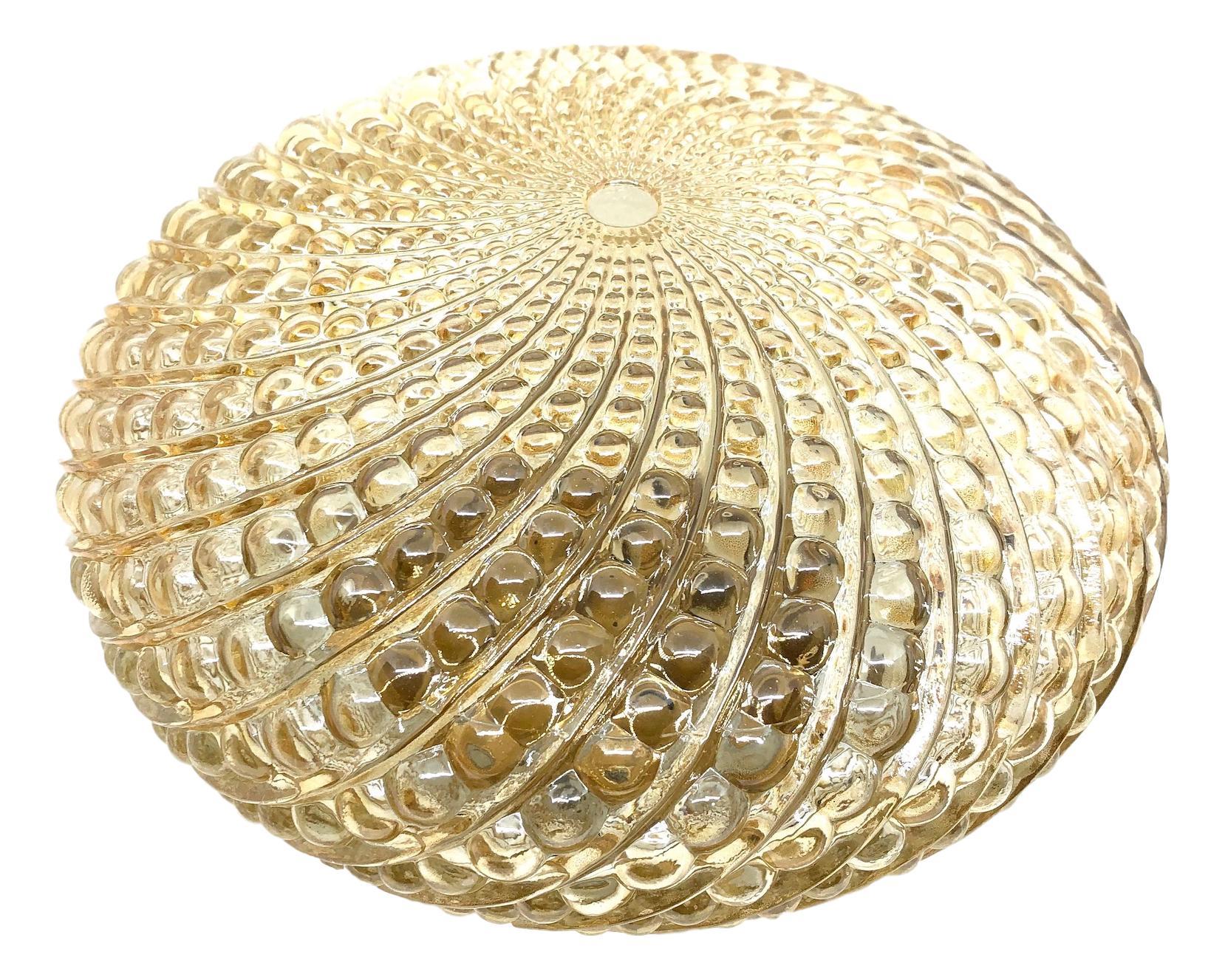 A round circa 1960s German bubble amber colored glass flush mount with metal fixture. The fixture requires one E27 Edison bulb up to 100 watt.