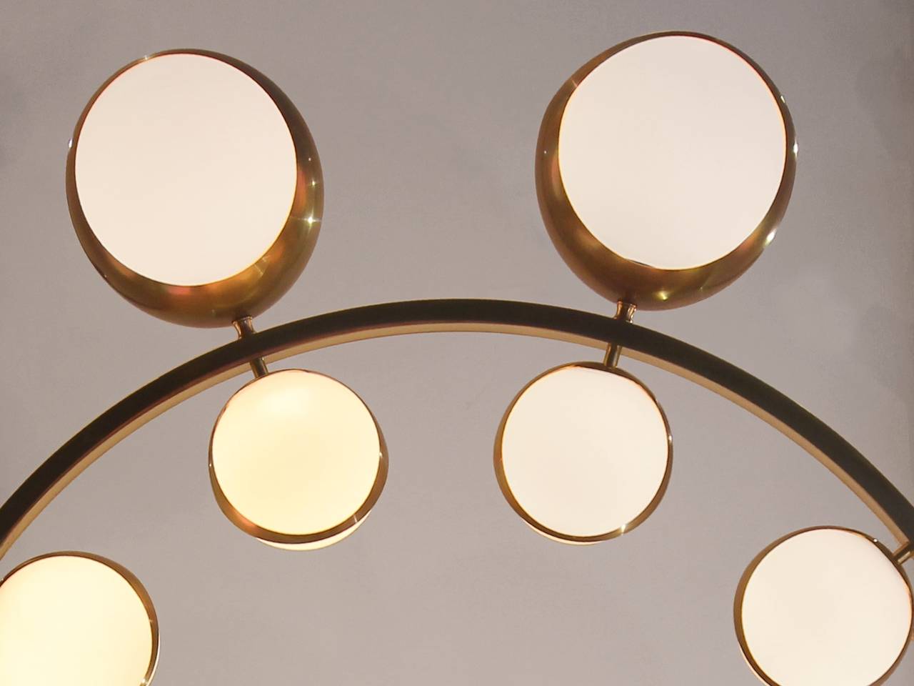 Large round chandelier in the taste of Stilnovo, Italy, circa 1960-1970, brass circle and mounting, the interior side of the circle enhanced by a series of ten illuminated white opal glass spheres and the outside of the circle with a series of ten