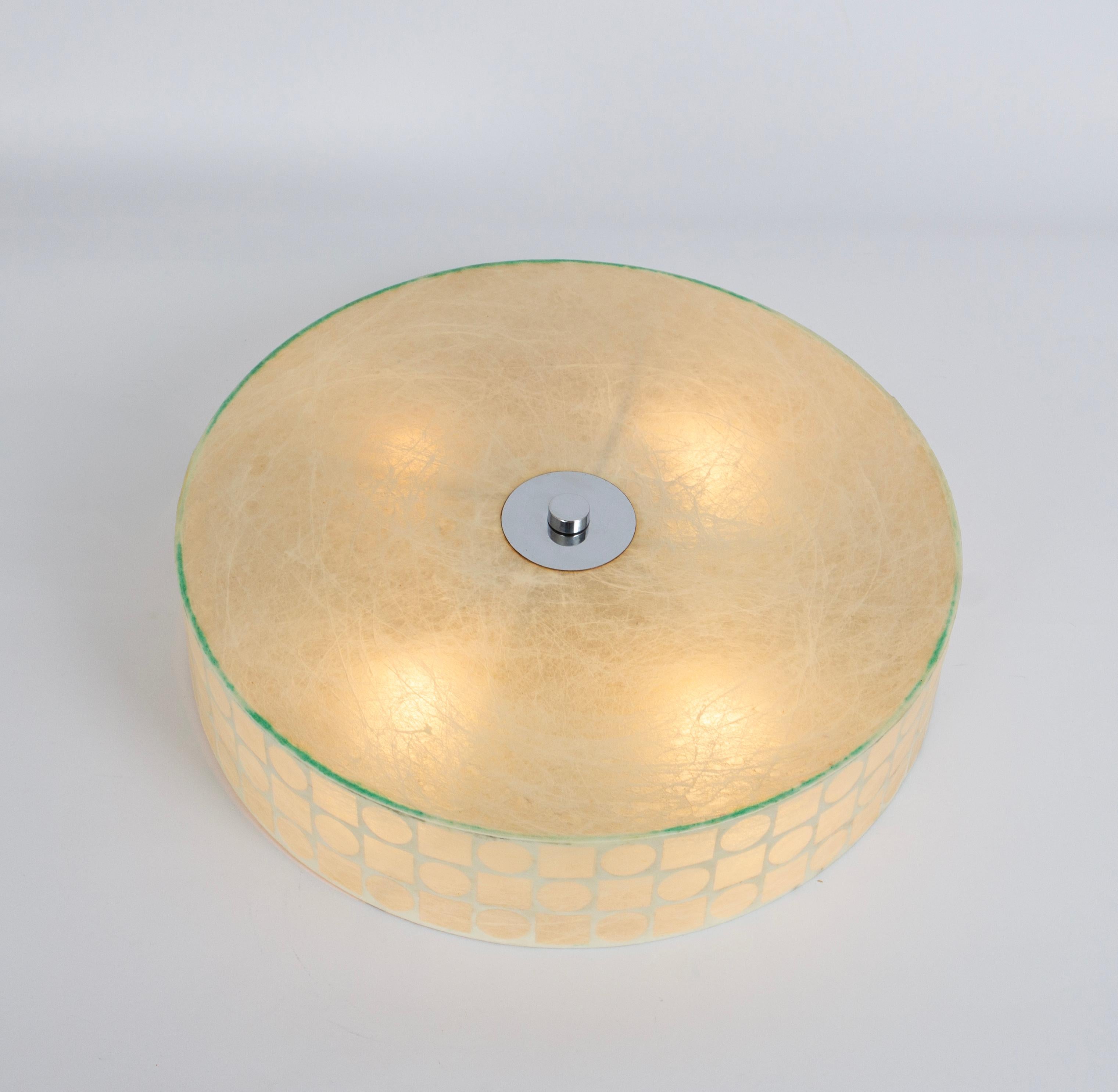 Cet élégant plafonnier Cocoon, fabriqué en Italie dans les années 1960, incarne le style épuré et intemporel qui rappelle le célèbre designer Achille Castiglioni. Sa forme ronde sophistiquée s'affine doucement vers l'extérieur, créant une silhouette