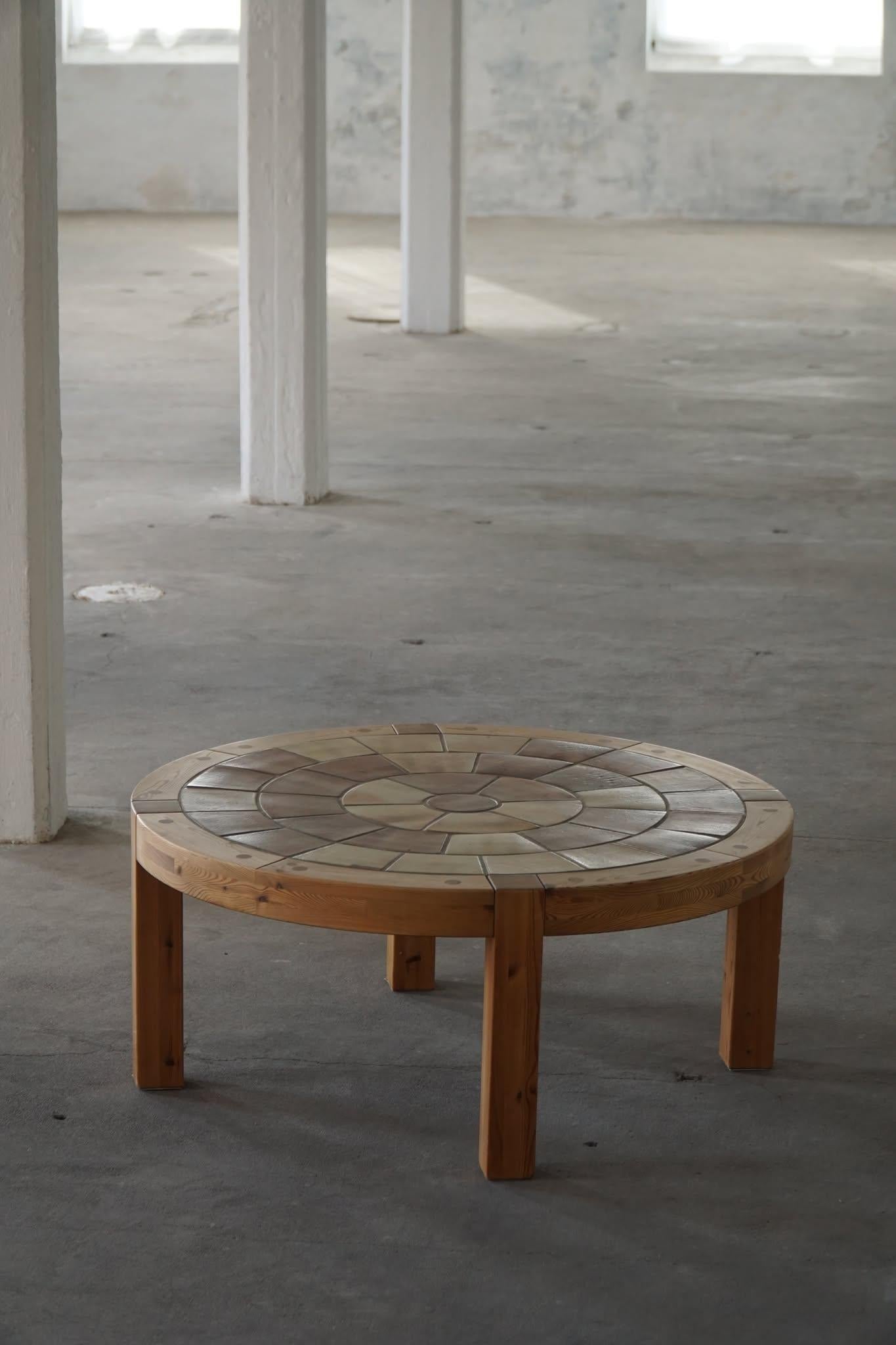 Une belle table ronde de salon ou de canapé, fabriquée en pin massif avec des carreaux de céramique faits à la main et des détails de chevilles visibles. Cette pièce exceptionnelle a été fabriquée au Danemark dans les années 1970 par Sallingboe et