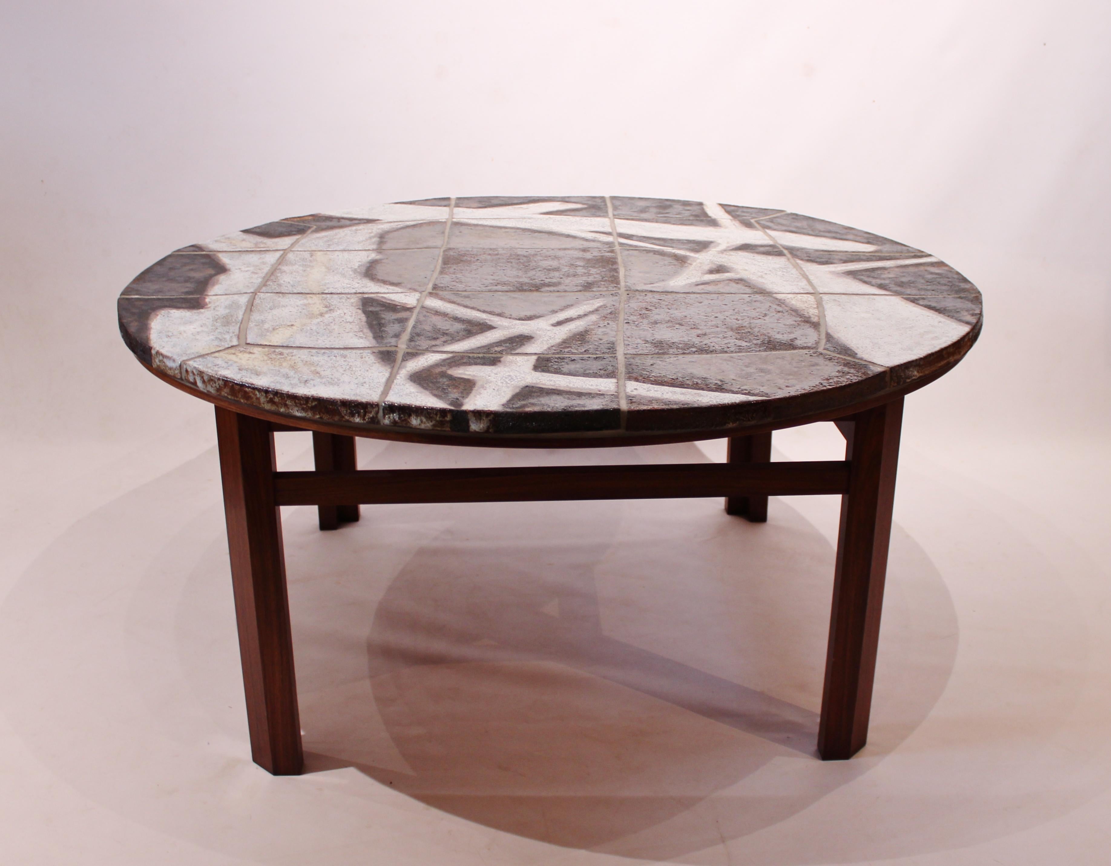 Large round coffee table with stone plate and frame of rosewood. The table is of Danish design from the 1960s and in great vintage condition.