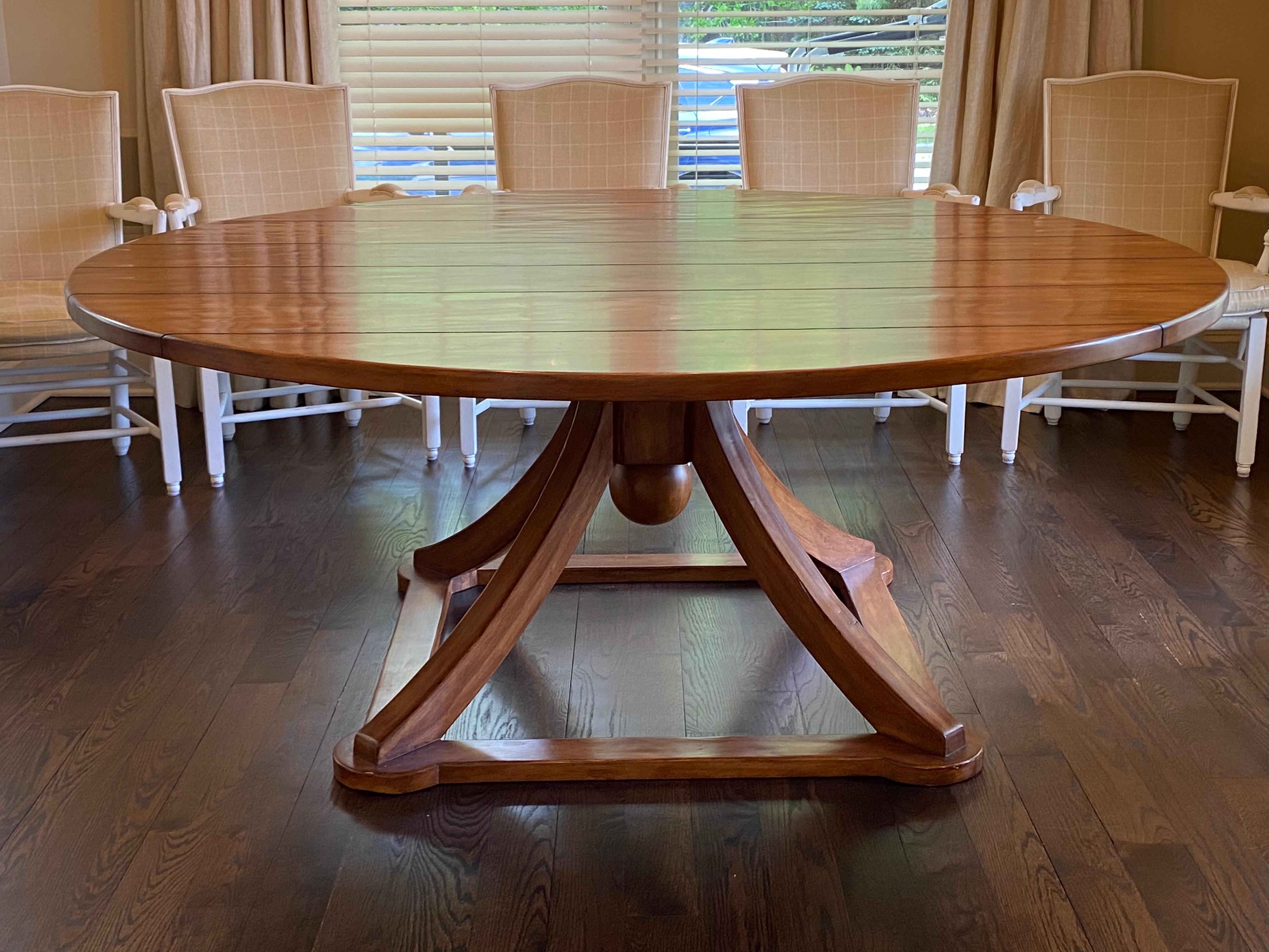 Large round dining table by Hamby LA with optional lazy susan.
Four splayed legs mounted to a square base and adorned with a ball. Top shows darkened plank-like grooves. Beautiful transitional dining table in very good condition. Optional round