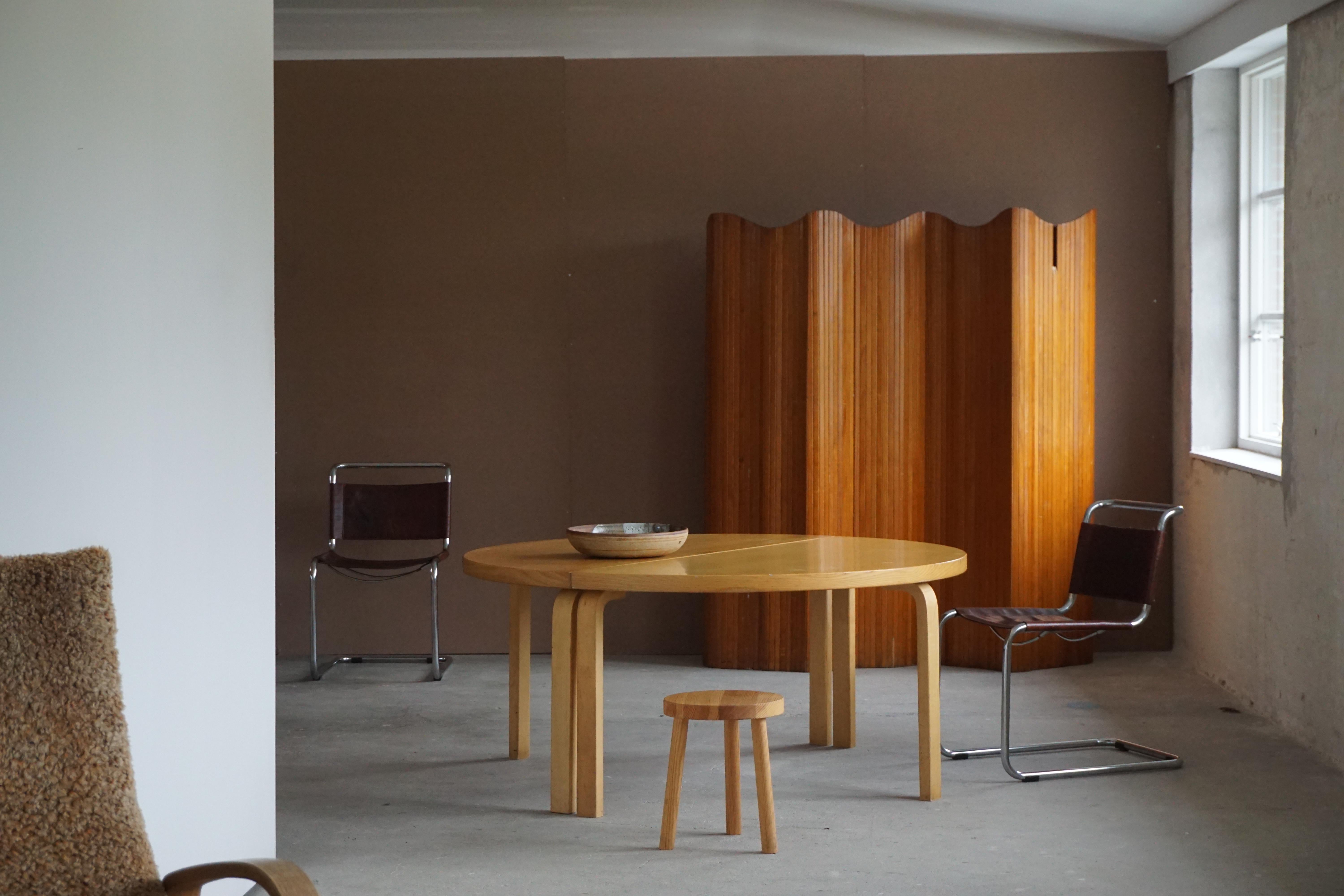 Large round dining table in birch by Alvar Aalto for Artek, 1980.
Designed in 1930s as a part of the iconic L-leg series.

Alvar Aalto (1898 - 1976), was a Finnish architect and designer. He was part of the Modern Movement of Architecture, but he