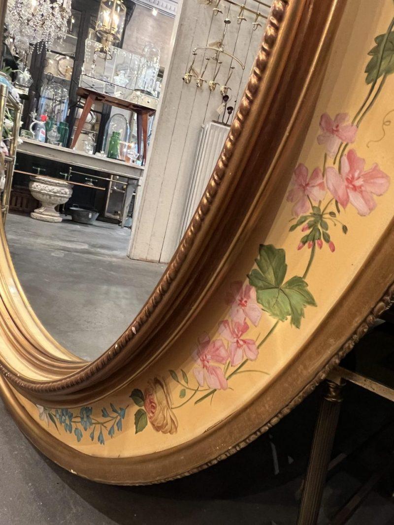 Mid Century and pretty Italian mirror, with beautiful decorative painted floral motifs around the handsome gilded wooden frame. Original mirrored glass from the 1950s.
