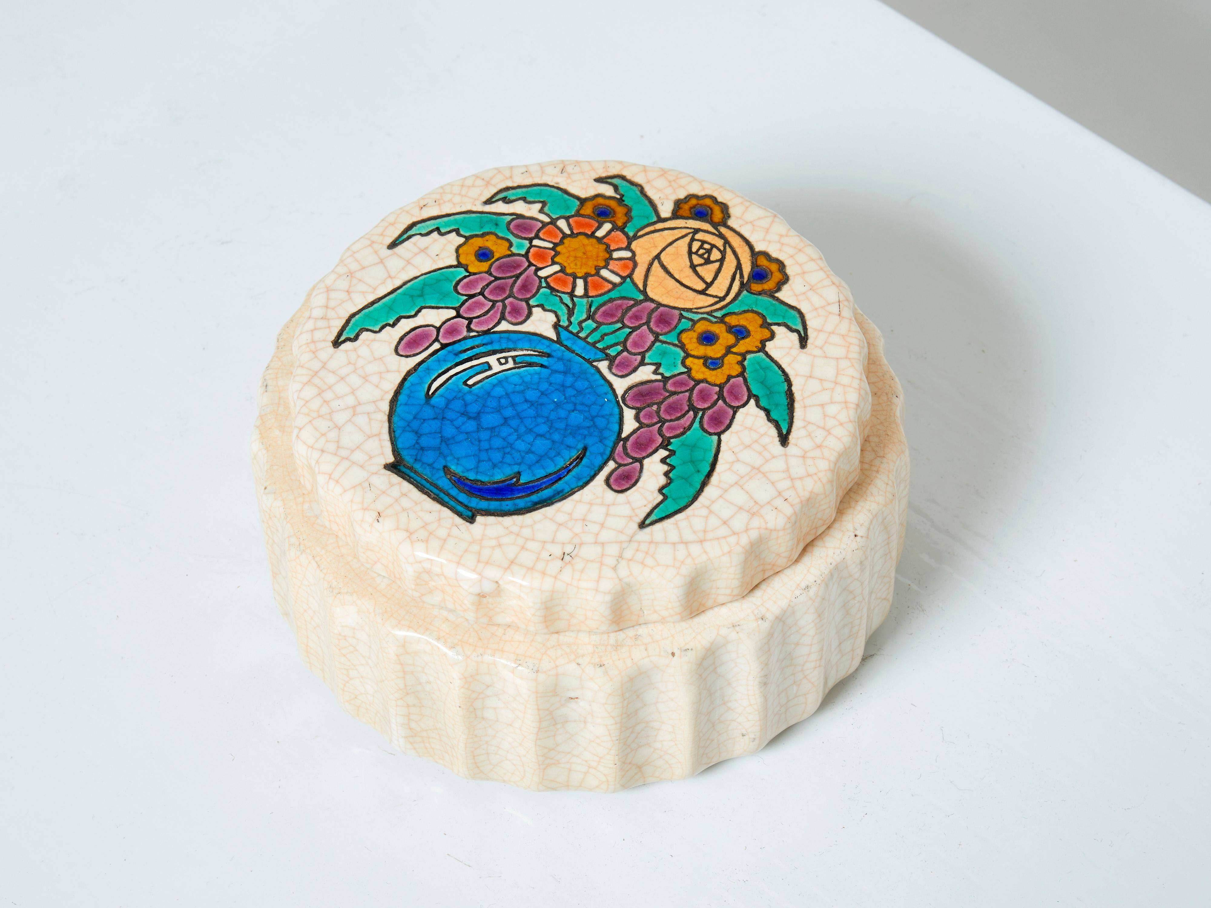 Seltene große runde Keramikdose von Faïenceries et Emaux de Longwy aus dem Art déco um 1930. Diese schöne Schachtel zeigt eine bunte Vase mit Blumen. Das Cremebeige ist mit der für Longwy typischen Craquelé-Glasur versehen. Die Longwy-Manufaktur