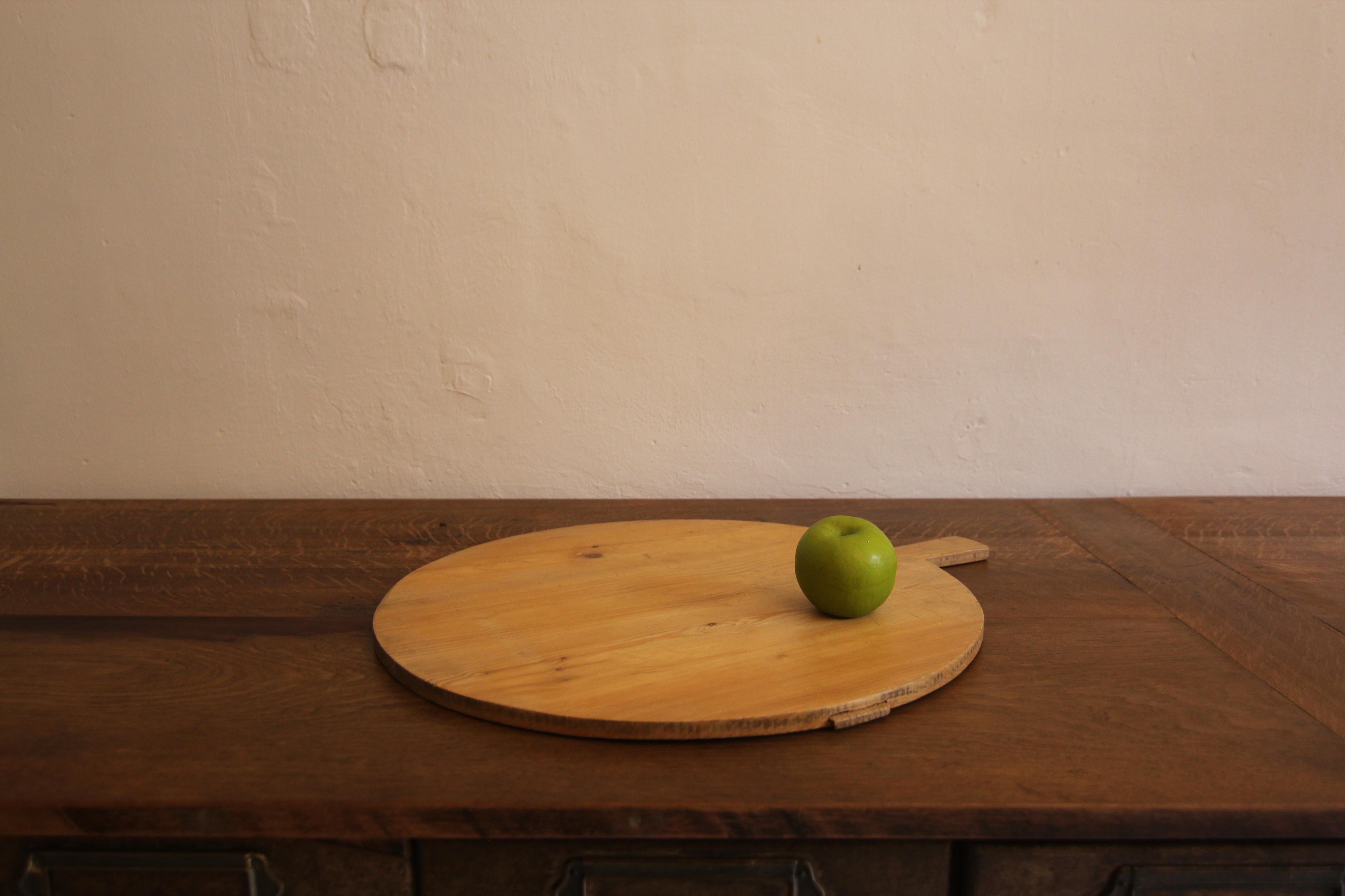 A large traditional German round serving board made of pine with beautiful patina and texture.
These boards are traditionally used to present different types of cheese often in combination with grapes and country bread. 
A very decorative piece that