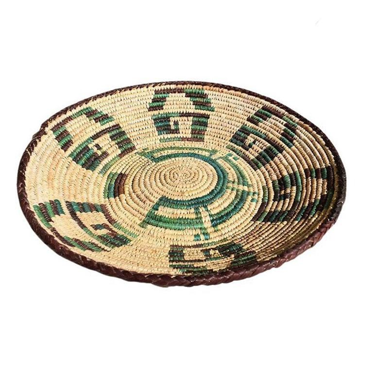 Un grand panier rond en fibre naturelle tressée en vert. Fabriquée à la main au Mexique par des artisans locaux, cette beauté sera fantastique accrochée au mur dans un groupement d'autres paniers, ou sur une table contenant des fruits.