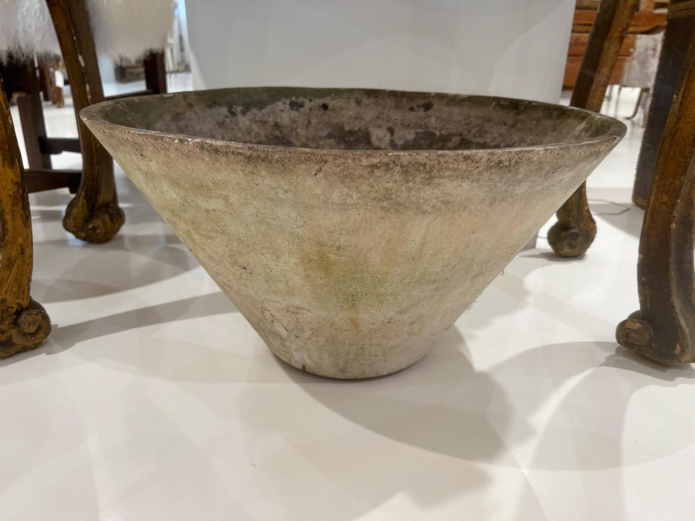 Willy Guhl was a famous Swiss designer who created planters in many shapes. These are formed from a slab of Eternit (a fibrous concrete material) moulded into a large conical vessel. 
 