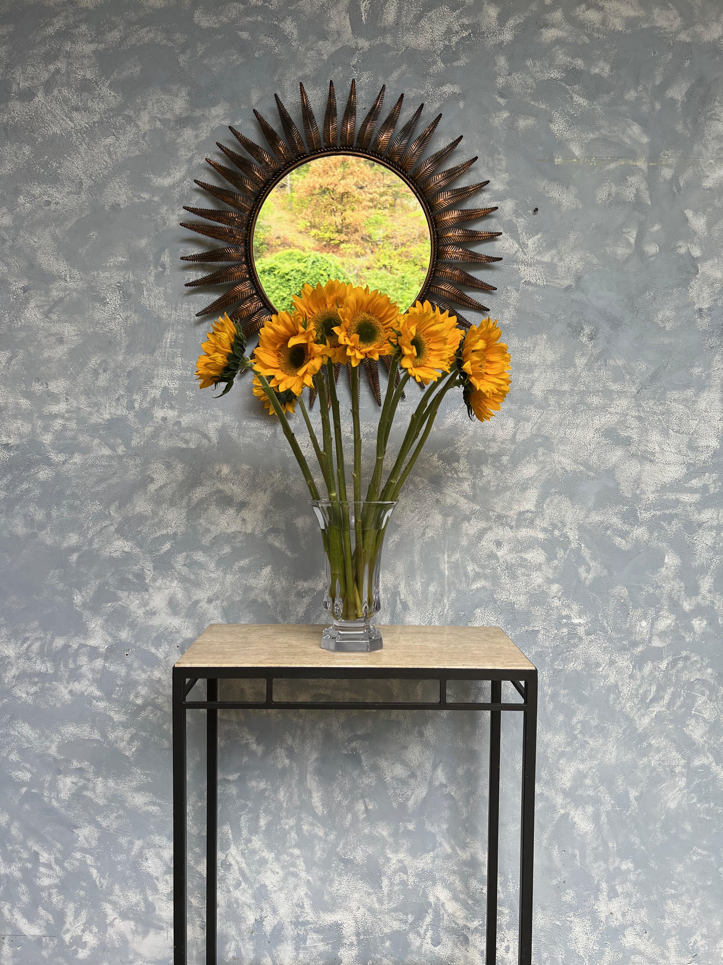 This large Spanish round copper plated mirror from the 1950s boasts a wonderfully proportioned mid century sunburst design with 40 evenly spaced rays, or leaves, encircling a braided interior frame. The metal showcases a richly patinated copper