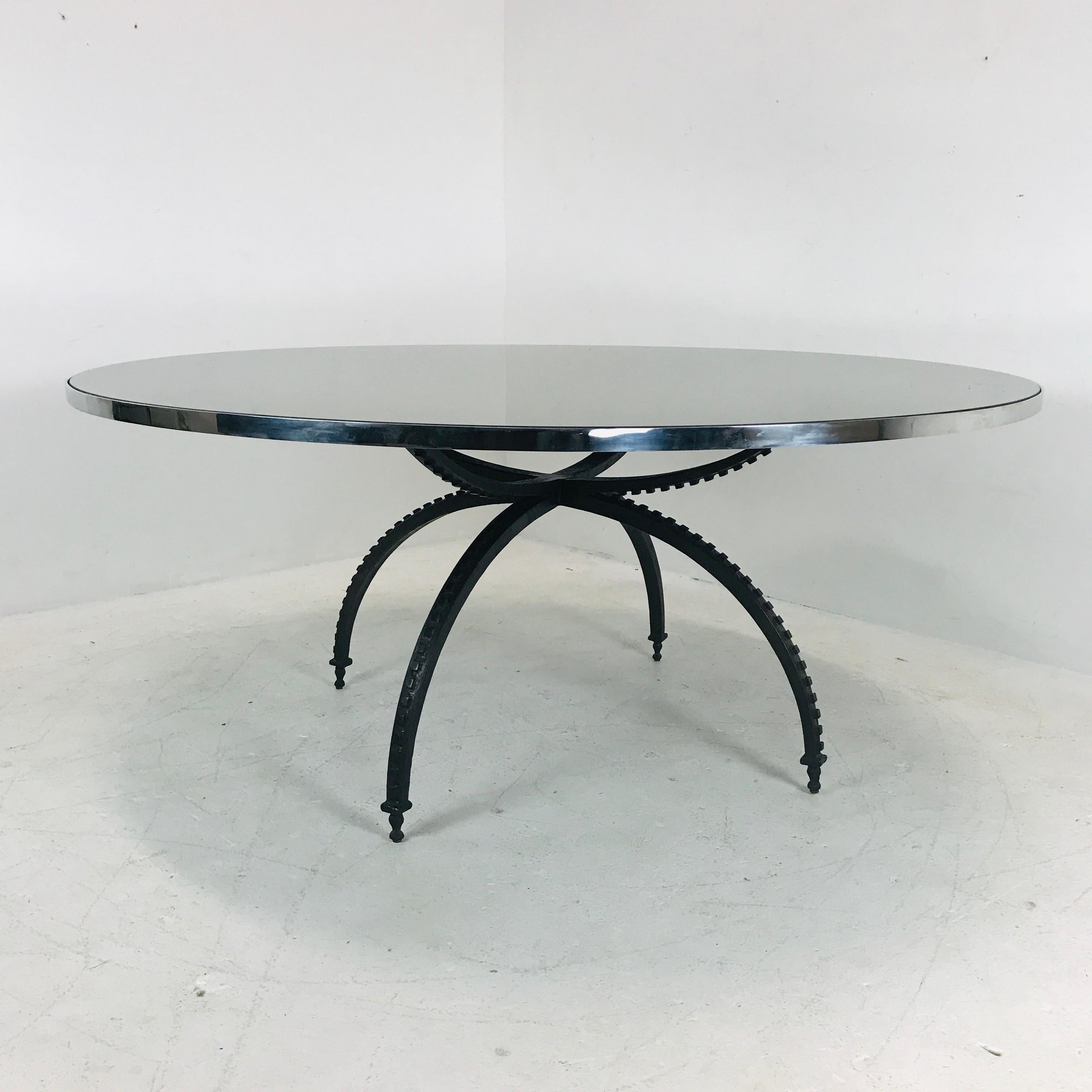 Four solid metal legs make up the base of this gorgeous, large round Baker dining table. Bronze mirror top measures 70