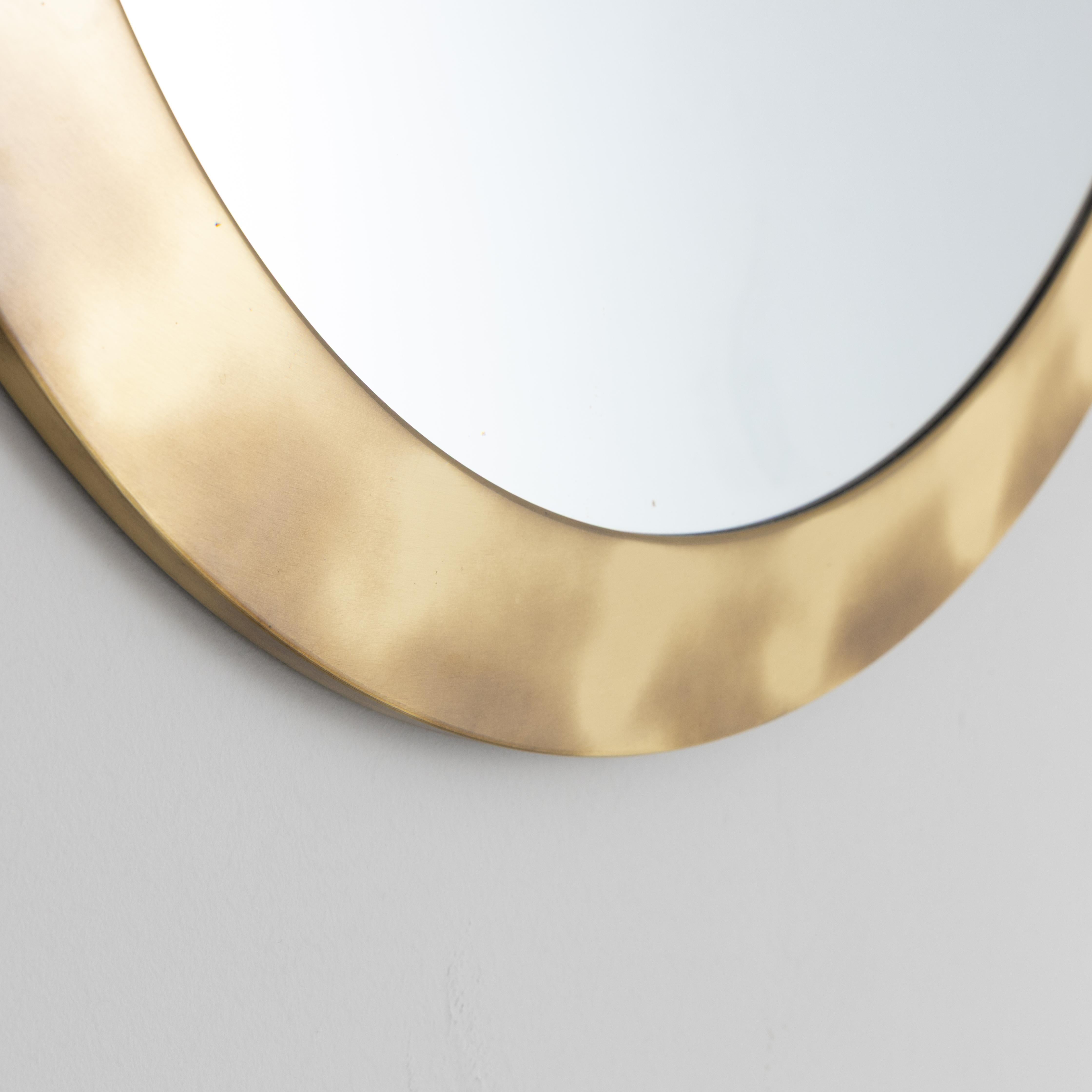 Large circular mirror with polished brass frame, produced by Valenti around 1970. The essentiality of the shape and the quality of the materials reflect the formal research of the Milanese company, active in combining elegance and constructive rigor