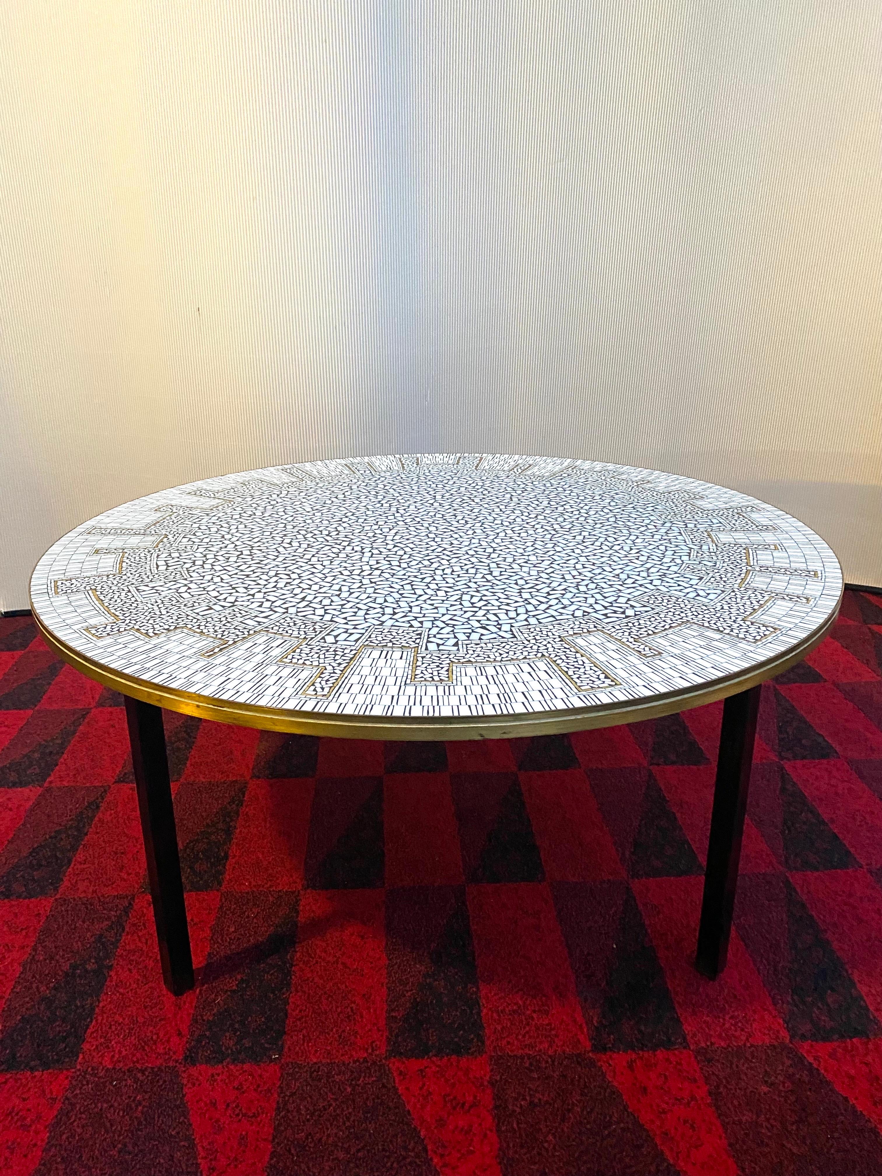 A Large Round Mosaic Midcentury Coffetable by Berthold Müller Oerlinghausen 50s.
Bought in 1958 directly on a Furniture Fair in Germany this Table has a Mosaic inlay that presents also classical antique and modern Memphis-lookalike graphical