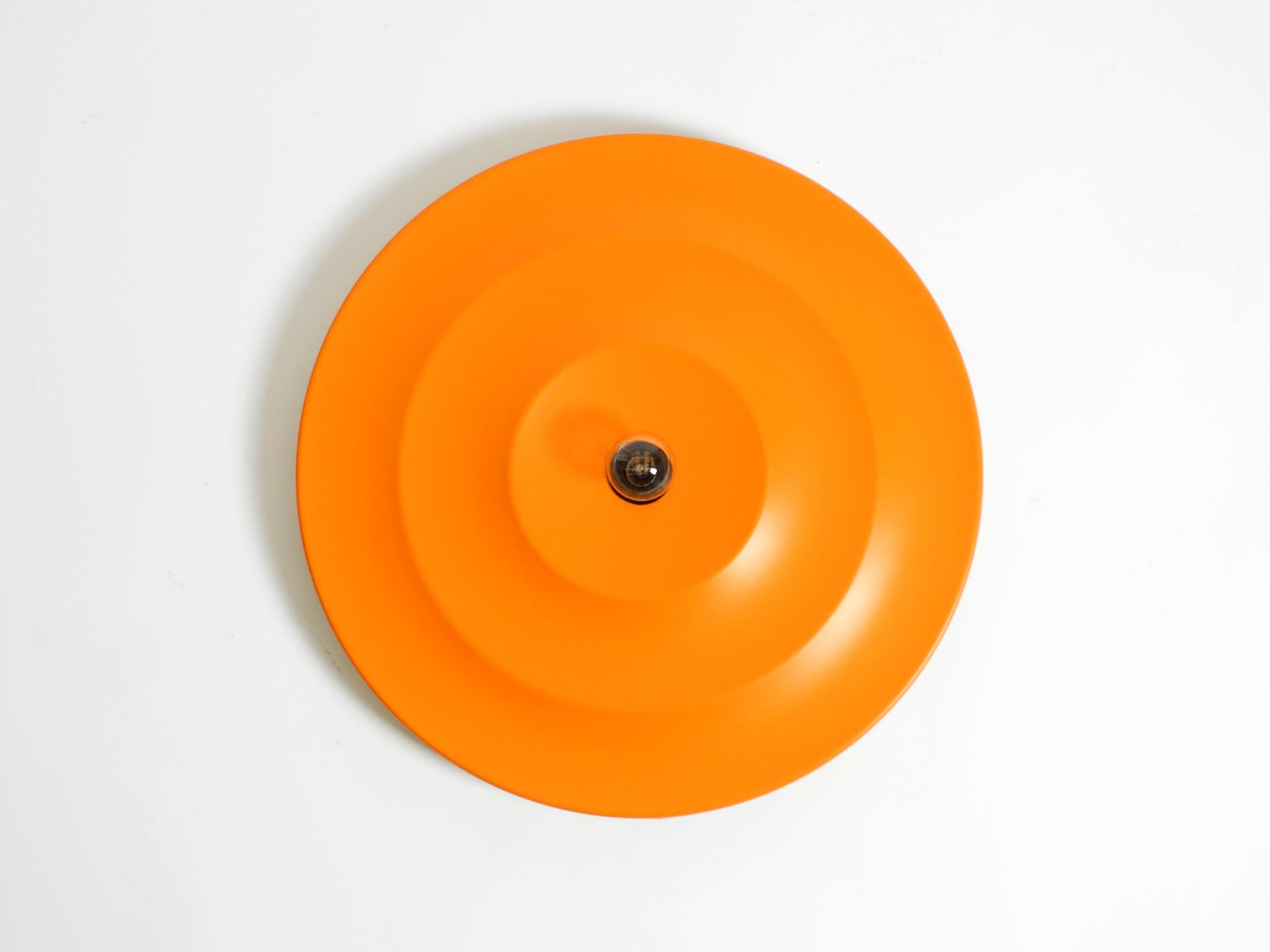 Lampada da soffitto o da parete in plastica minimalista, grande e originale del Mid-Century Modern Age. Nell'allora trendy colore arancione.
Design tipico della Space AGE degli anni '60 in condizioni originali.
In condizioni vintage molto buone per