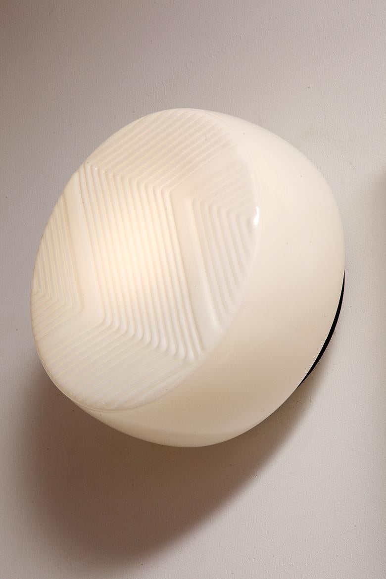 Large round relief milky white glass Art Deco wall lamp with black metal bezel For Sale 5