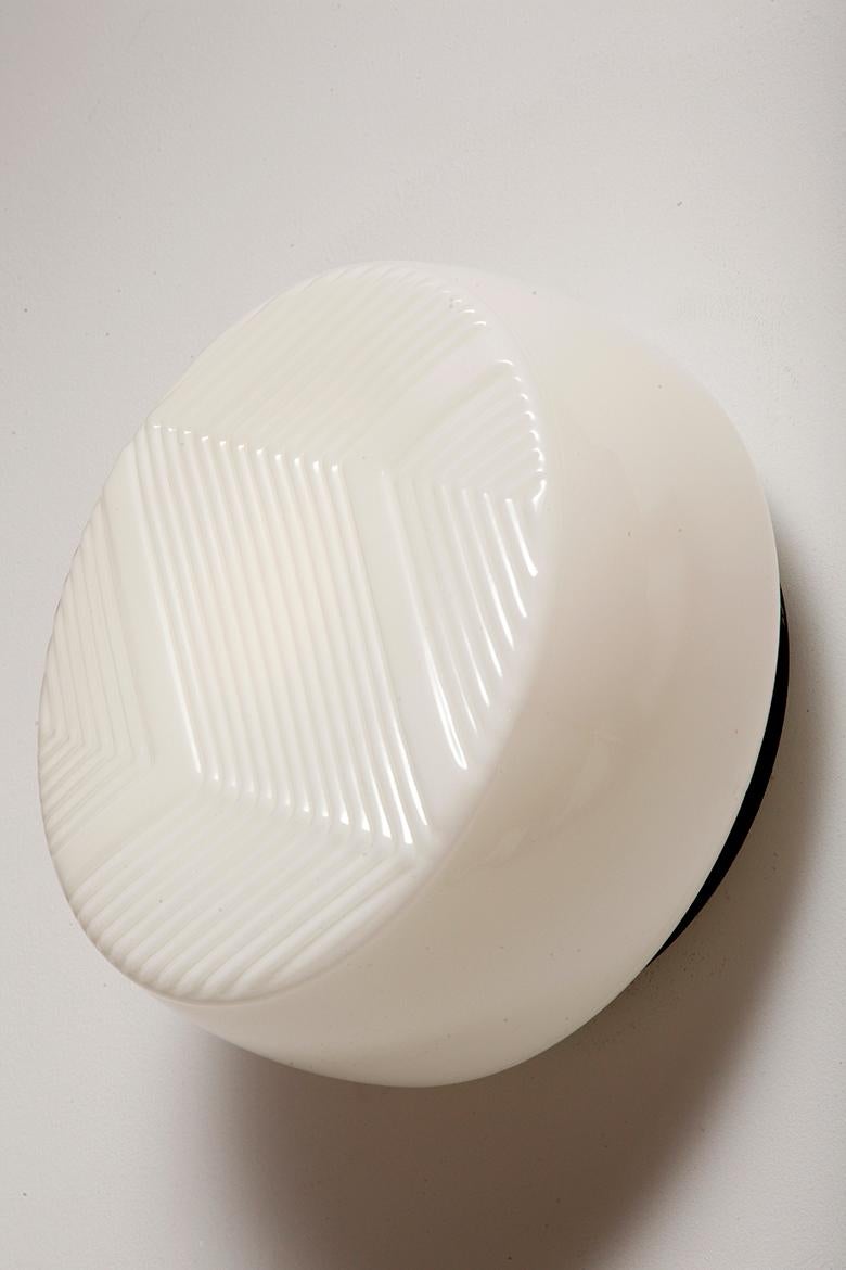 Mid-Century Modern Large round relief milky white glass Art Deco wall lamp with black metal bezel For Sale