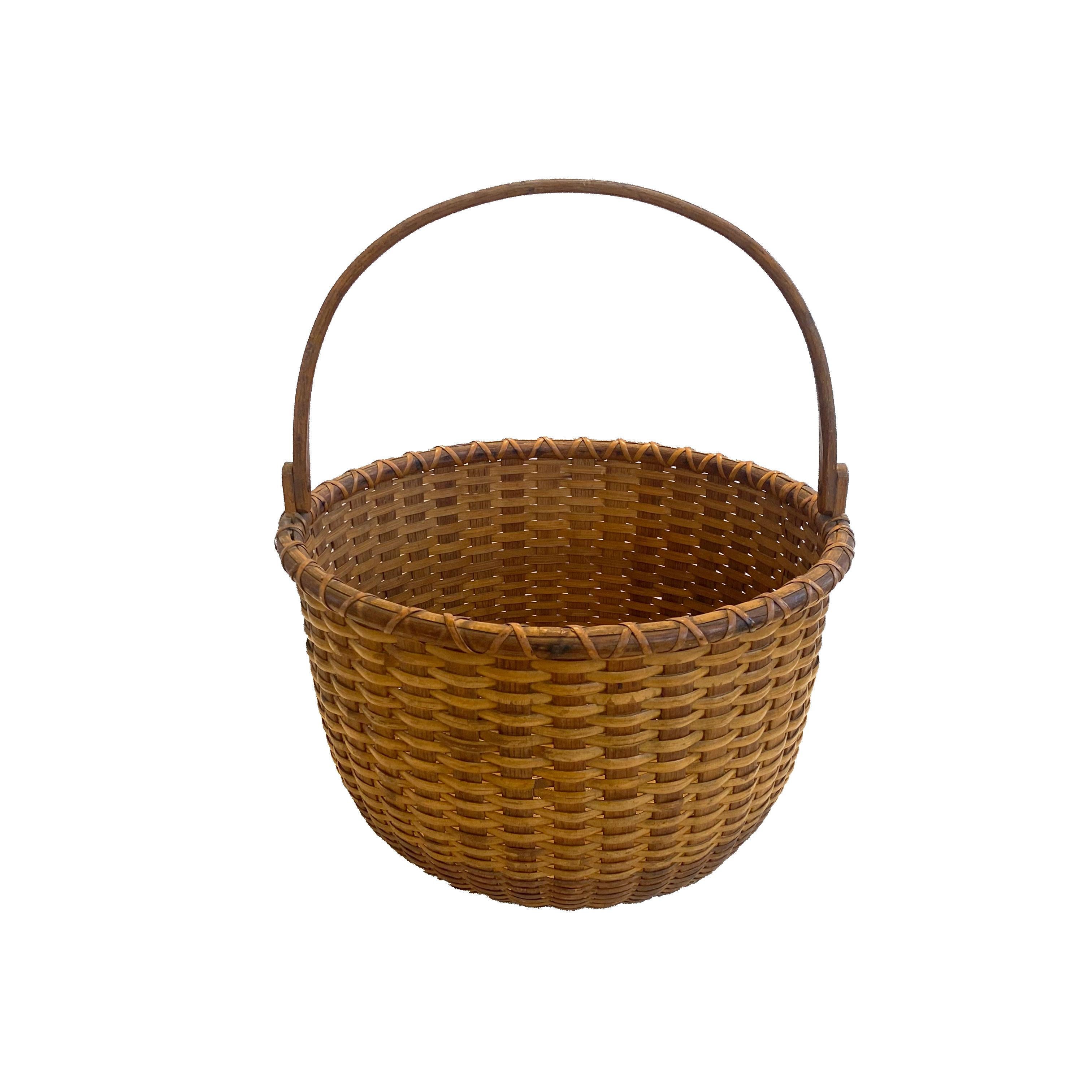 10 ½” Open round Nantucket lightship basket with carved wooden oak ears with oak staves, handle and rim. The bottom is turned out of Pine and the interior is markedin ink with the orignal stencil, 