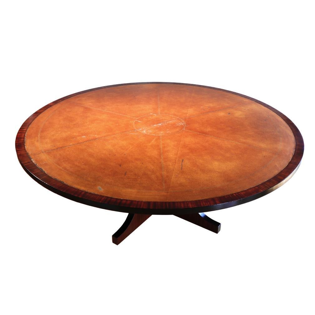 Large round Spanish mahogany dining table attributed to Valenti, Barcelona, circa 1970. In two pieces the top with an embossed and gold stamped tan leather-like inlaid surface, banded with a mahogany veneer and an ebonized edge, supported and