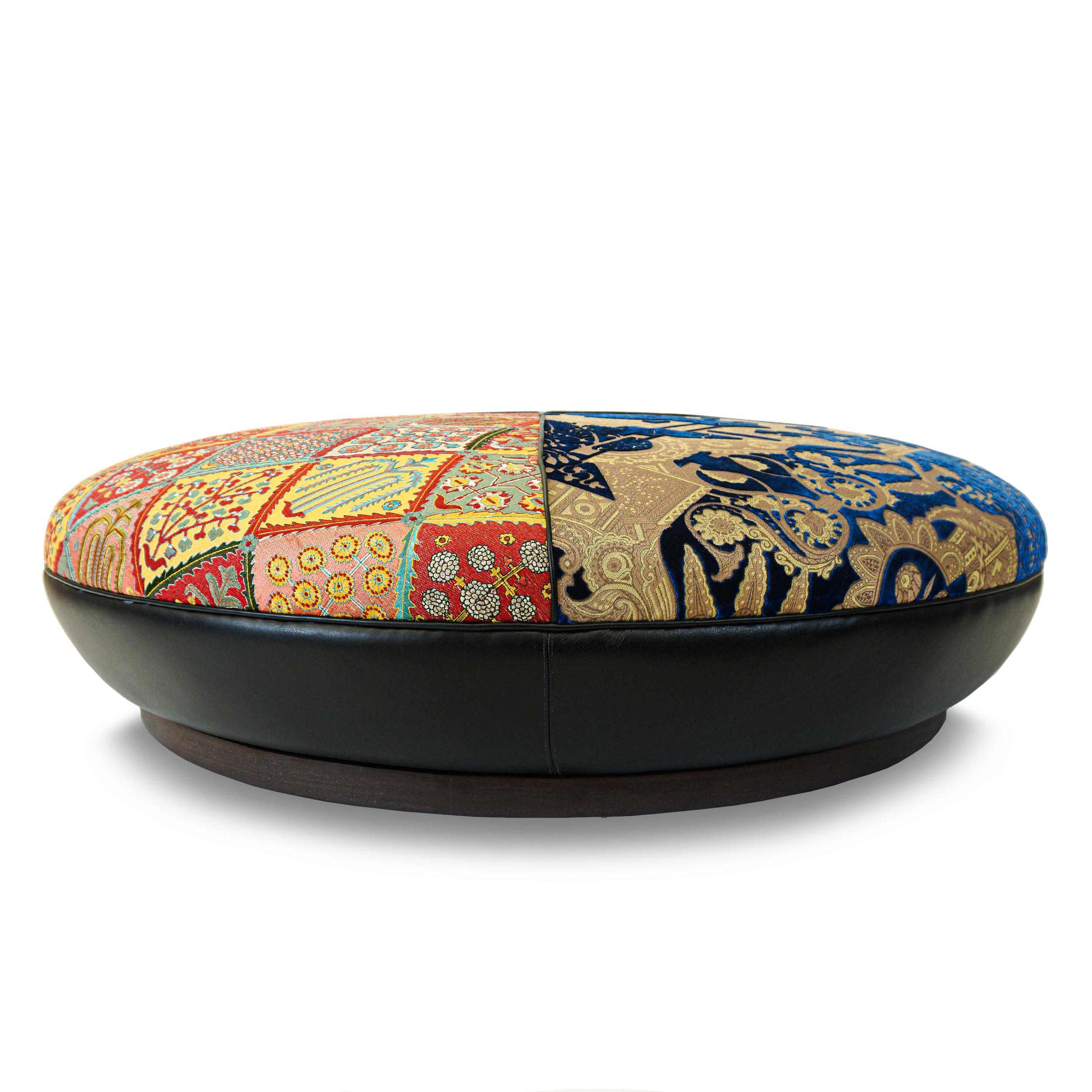 About this piece
Sprawling low round ottoman upholstered in an eclectic mix of three fabrics featuring embroidery, cut velvet, and jacquard and with a vinyl plinth base with a stained wood platform. Seat is firm and crowned but can support a tray.