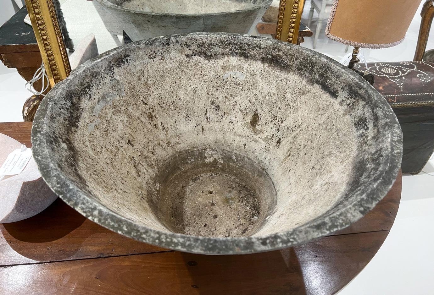 Willy Guhl was a famous Swiss designer who created planters in many shapes. These are formed from a slab of Eternit (a fibrous concrete material) moulded into a large conical vessel. 

This large round jardiniere features a distinctive, tapered