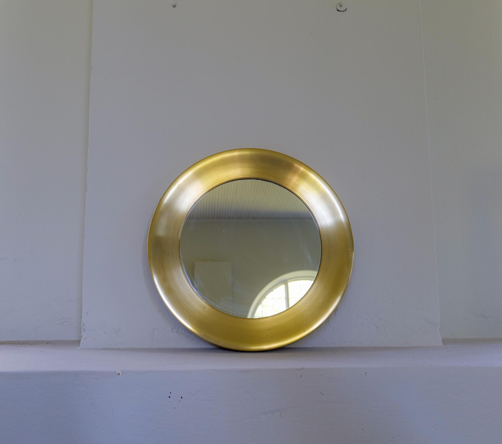 Round glass mirror from Glasmäster with brass frame. It was made in Sweden for Glasmäster (glass master) in Markaryd and is often connected to Hans Agne Jakobsson Work in Markaryd.

This mirror is in good condition, one small bump and some stains