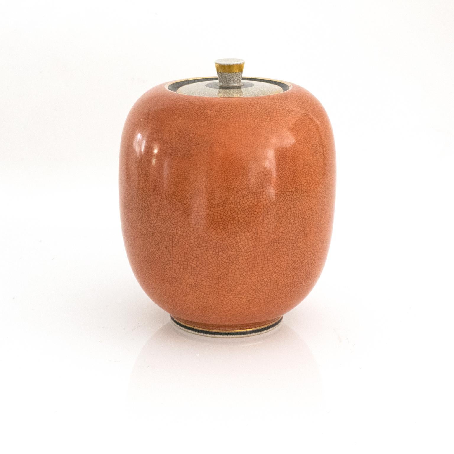 Large Royal Copenhagen ceramic jar in coral and white (craquelure) crackle glaze and detailed in gold. Made in Denmark, circa 1940s.

Measures: Height 10