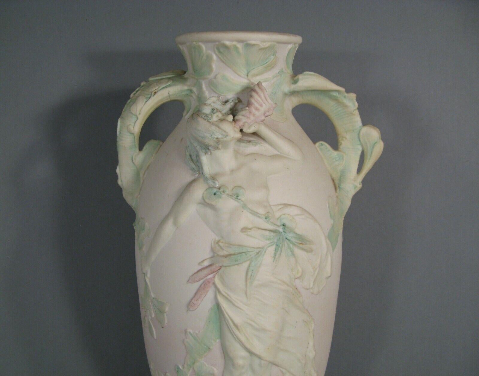 Questo grande vaso in porcellana policroma con doppio manico è realizzato nel caratteristico stile Art Nouveau. Il vaso raffigura un giovane che suona un corno in mezzo a un'intricata serie di motivi vegetali. Anche se probabilmente è stato prodotto