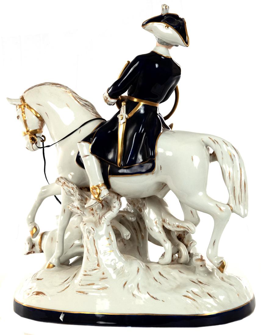 A very large lead white, cobalt, and gilt porcelain sculptural group of a well modeled eighteenth-century gentleman with hunting horn atop a horse and alongside three jumping hunting dogs, stamped and signed on the bottom.