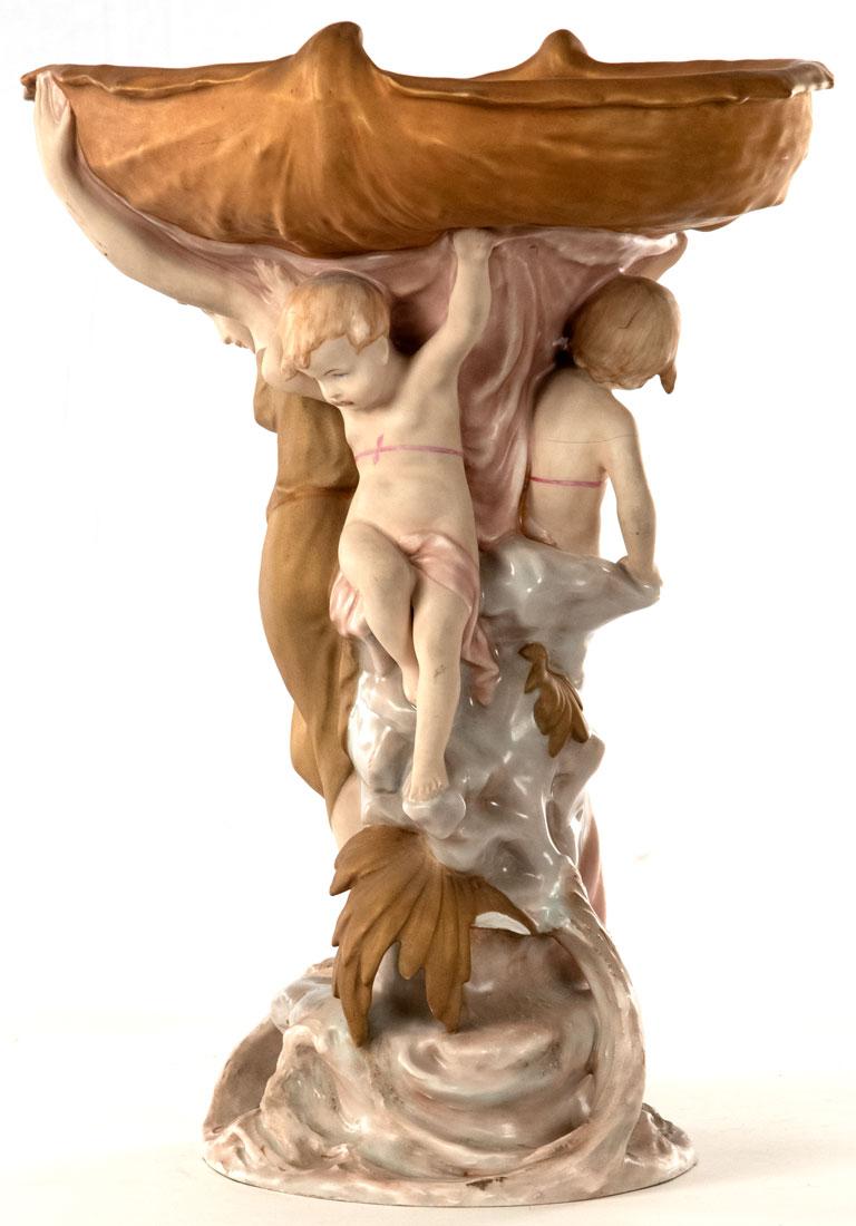 Featuring a nymph an putto frolicking below at the base of a large tree, this porcelain table centerpiece was made by the Czechoslovakian firm.