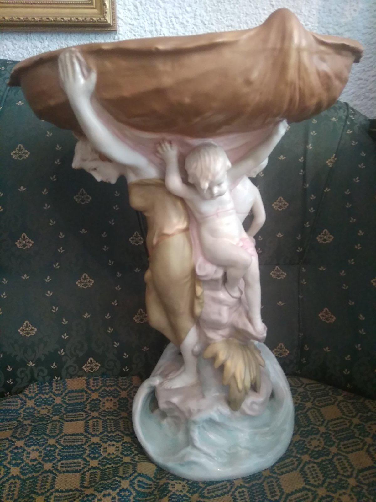 Large royal dux porcelain figural centerpiece, (circa 1950)

Featuring a nymph and putto frolicking below at the base of a large tree, this porcelain table centerpiece was made by the Czechoslovakian firm.

Measures: 20 x 16 x 12 in.