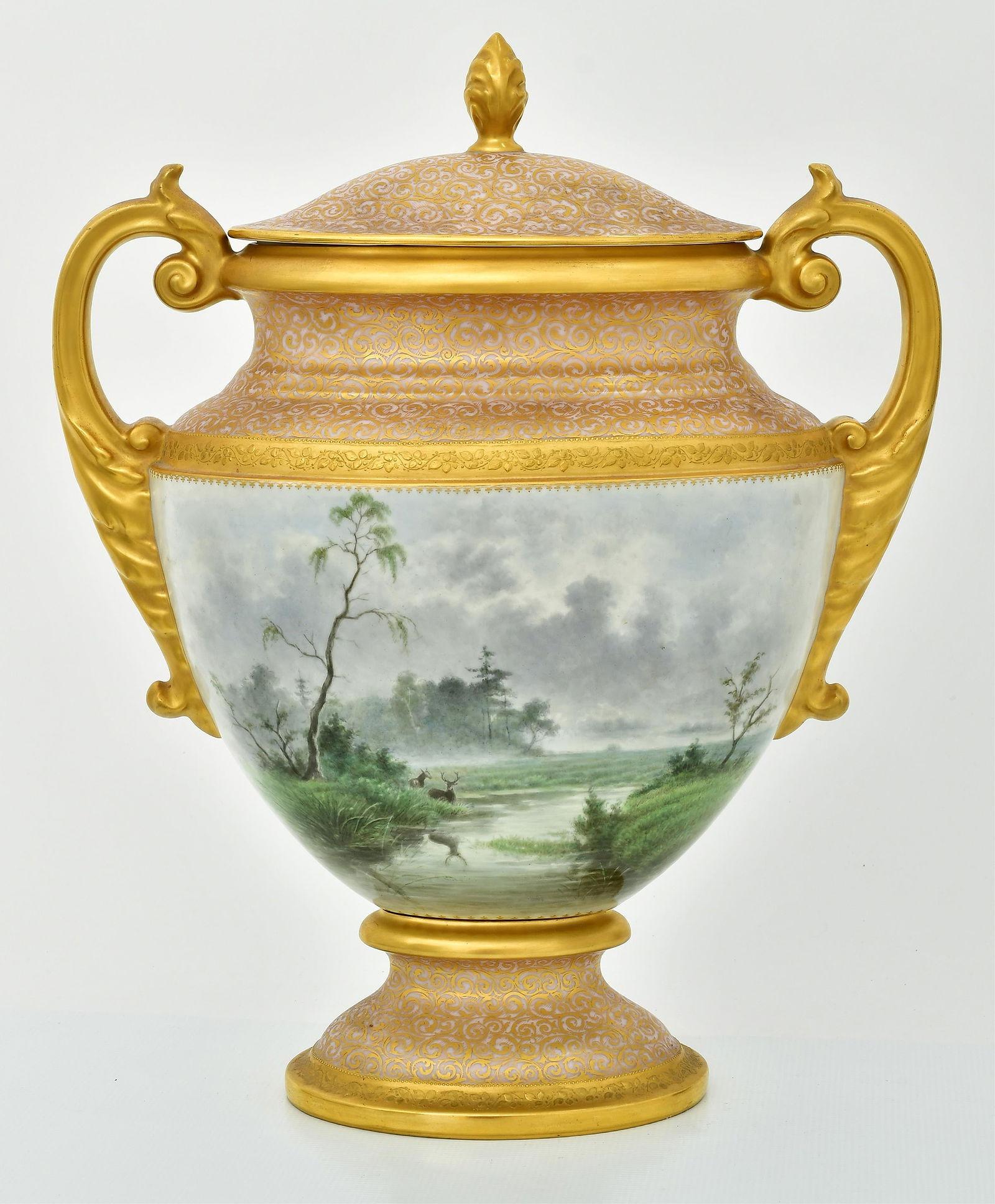 Ovale Porzellanvase mit Deckel (Urne), fein bemalt, auf der einen Seite eine Frau am Meer, auf der gegenüberliegenden Seite eine Waldlandschaft mit Hirschen darstellend.  20 x 16 1/4 x 8 Zoll.  Mit königlich-wienerischer blauer Unterglasurmarke in