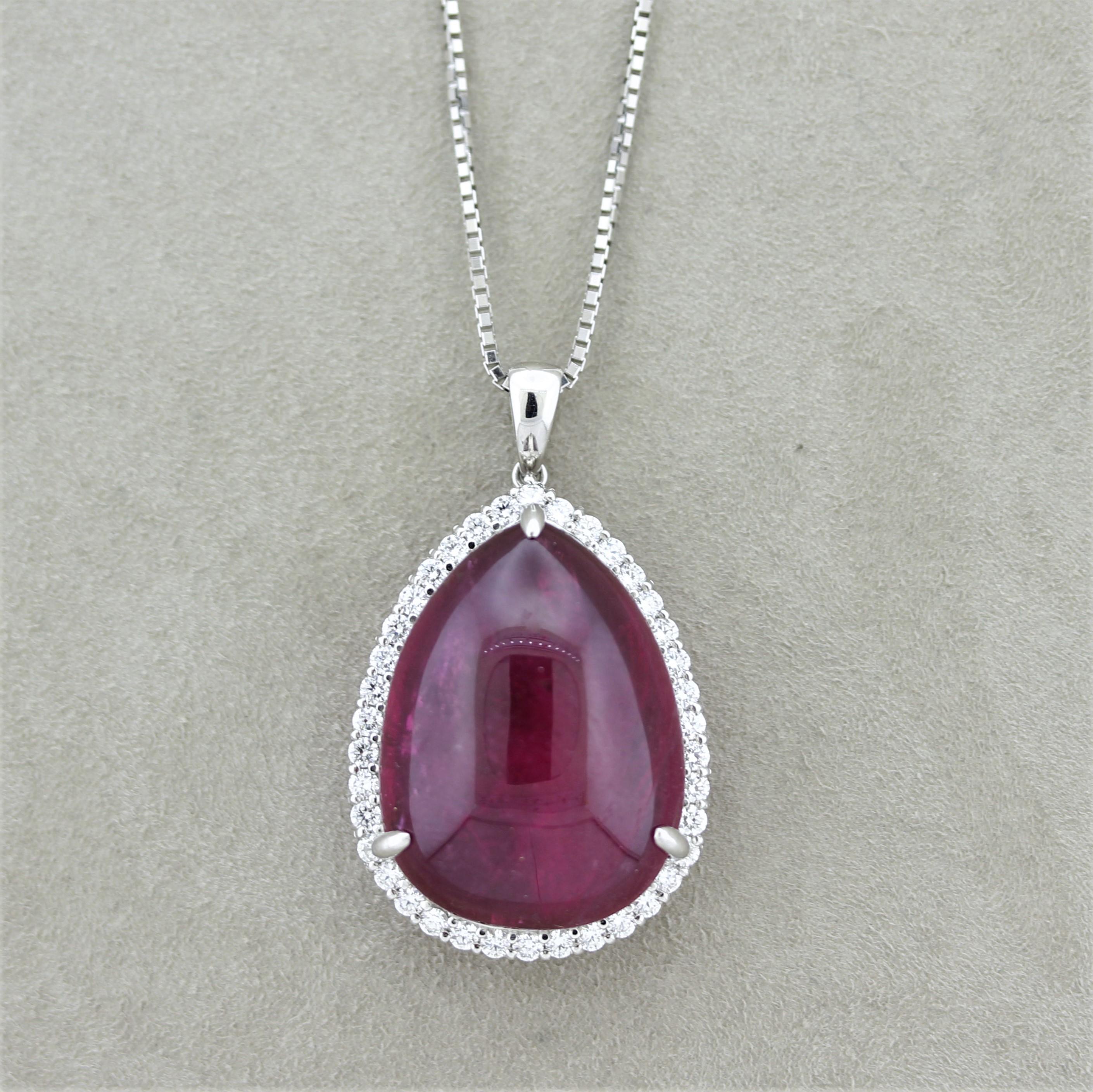 A large and impressive rubellite tourmaline takes center stage of this platinum made pendant. It weighs 27.04 carats and has a rich royal slightly pinkish-red color giving it the name rubellite. It is complemented by 0.76 carats of round