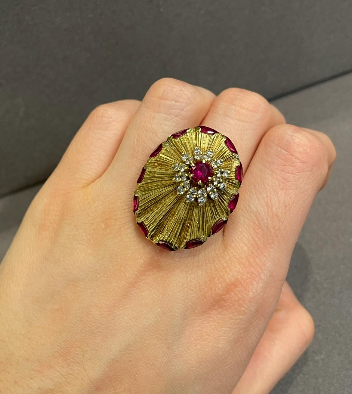 Grande bague de cocktail en rubis et diamants 

Bague de cocktail en or jaune en forme de disque présentant un motif de soleil texturé, rehaussé de rubis taillés en marquise le long de la bordure. Au centre, un rubis de taille ronde est entouré de