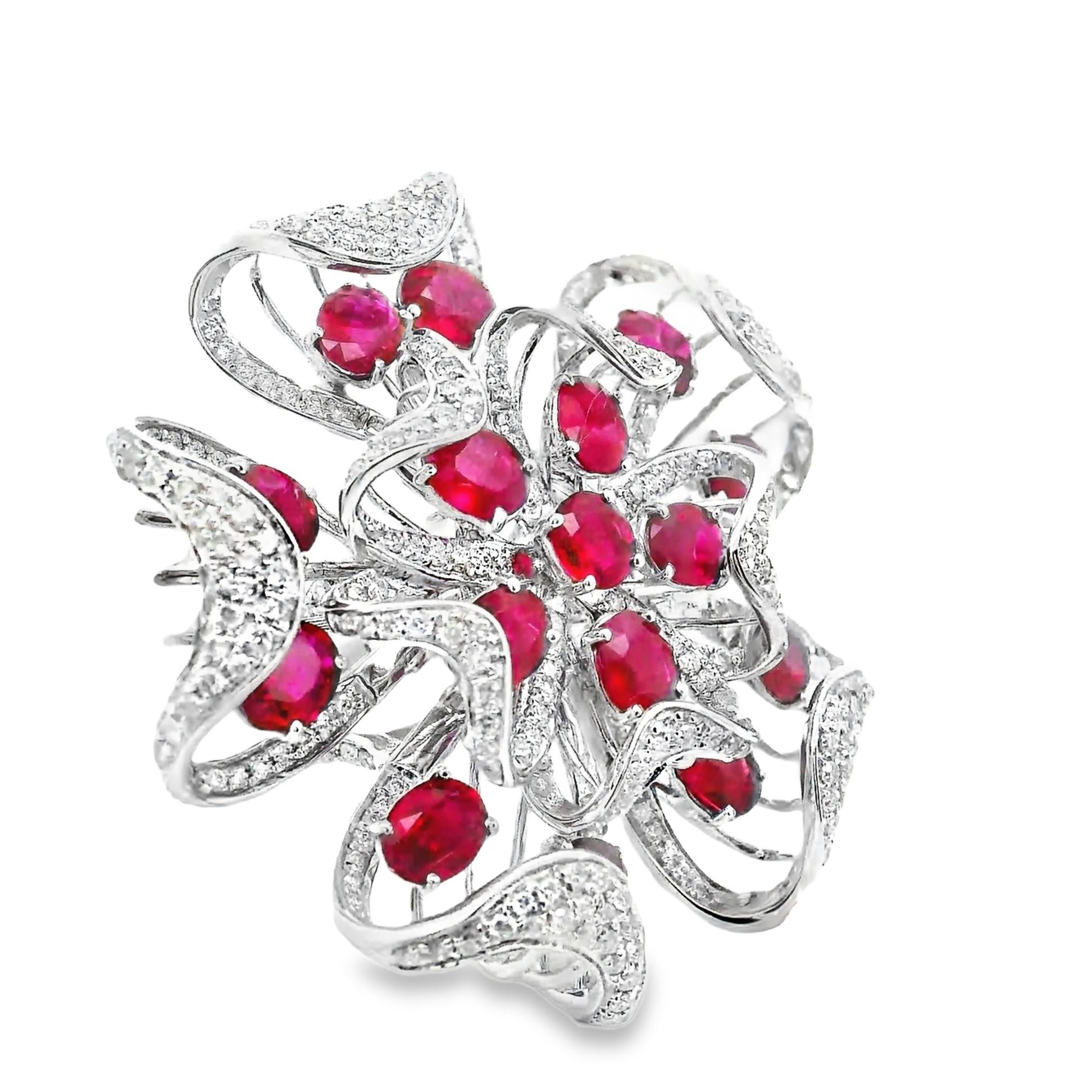 A large and impressive 18k white gold flower set with gem rubies and diamonds! The elegant flower features 16 very fine vivid red rubies weighing 6.83 carats. The rubies are of “pigeon blood” quality, meaning they have a very intense pure red color.