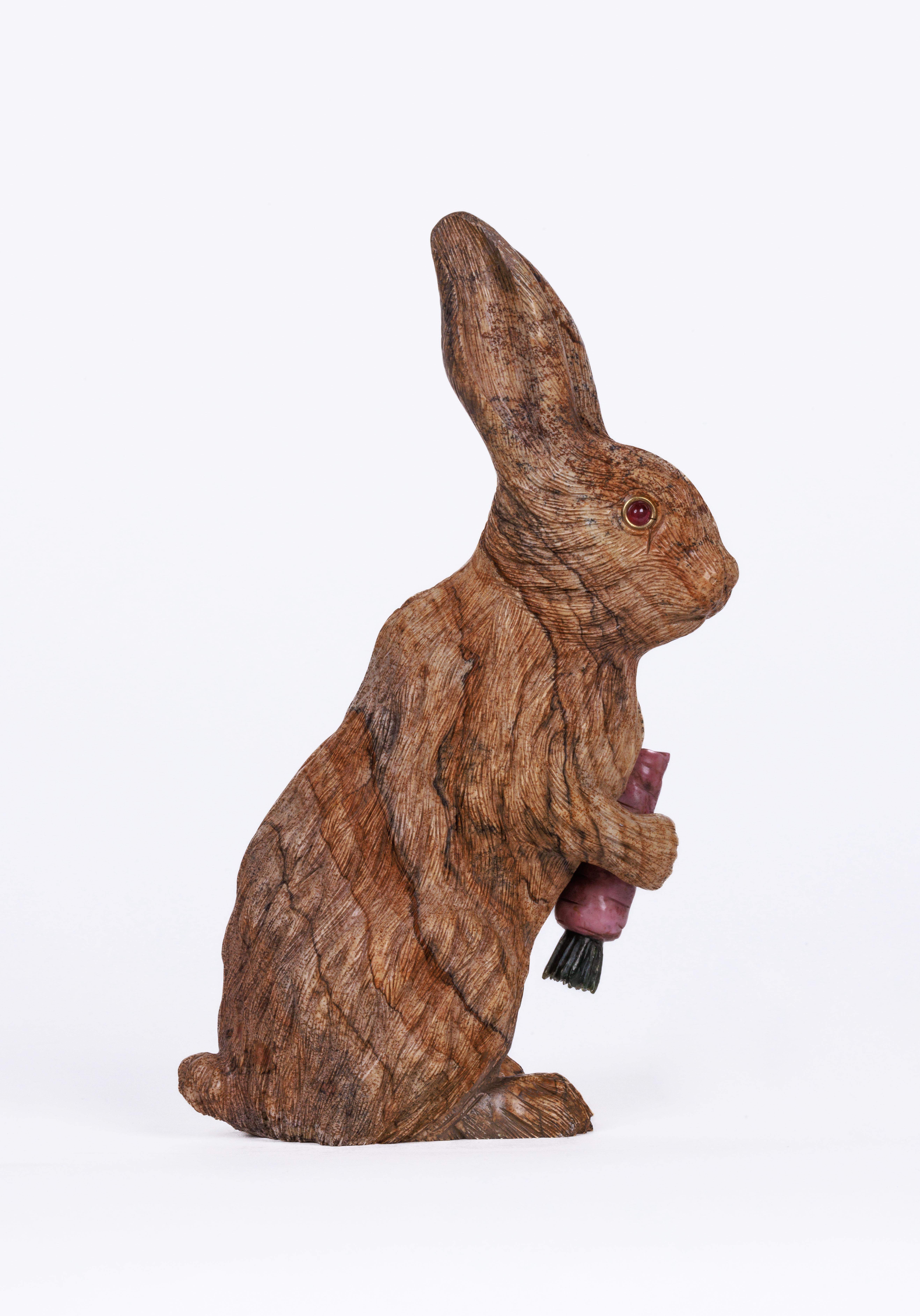 A large Russian carved Jasper hardstone figure of a rabbit, in the style of Faberge.

With 14K gold and ruby eyes.

Realistically carved, figure of a bunny rabbit holding a carrot carved from rhodonite and nephrite, set with ruby and gold